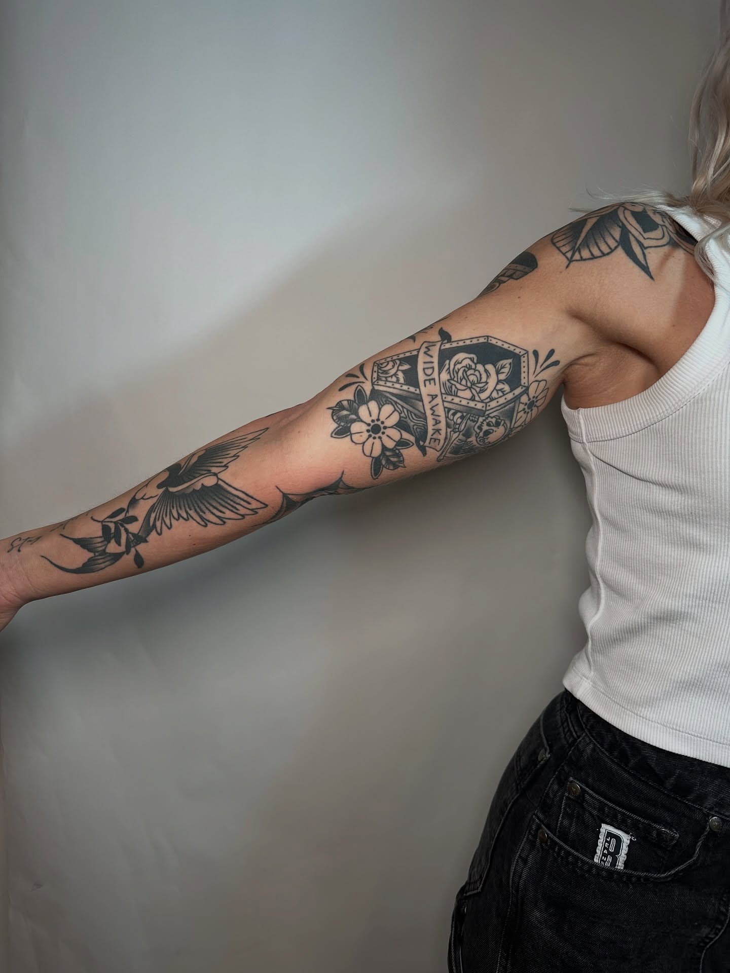 Floral and geometric design black and grey tattoo on the forearm by Heather Cherish