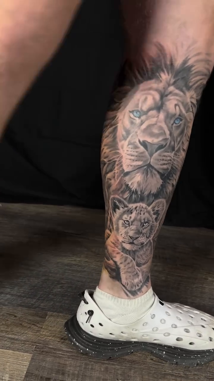 Lion and cub with jungle foliage realism tattoo by Matthew Doherty