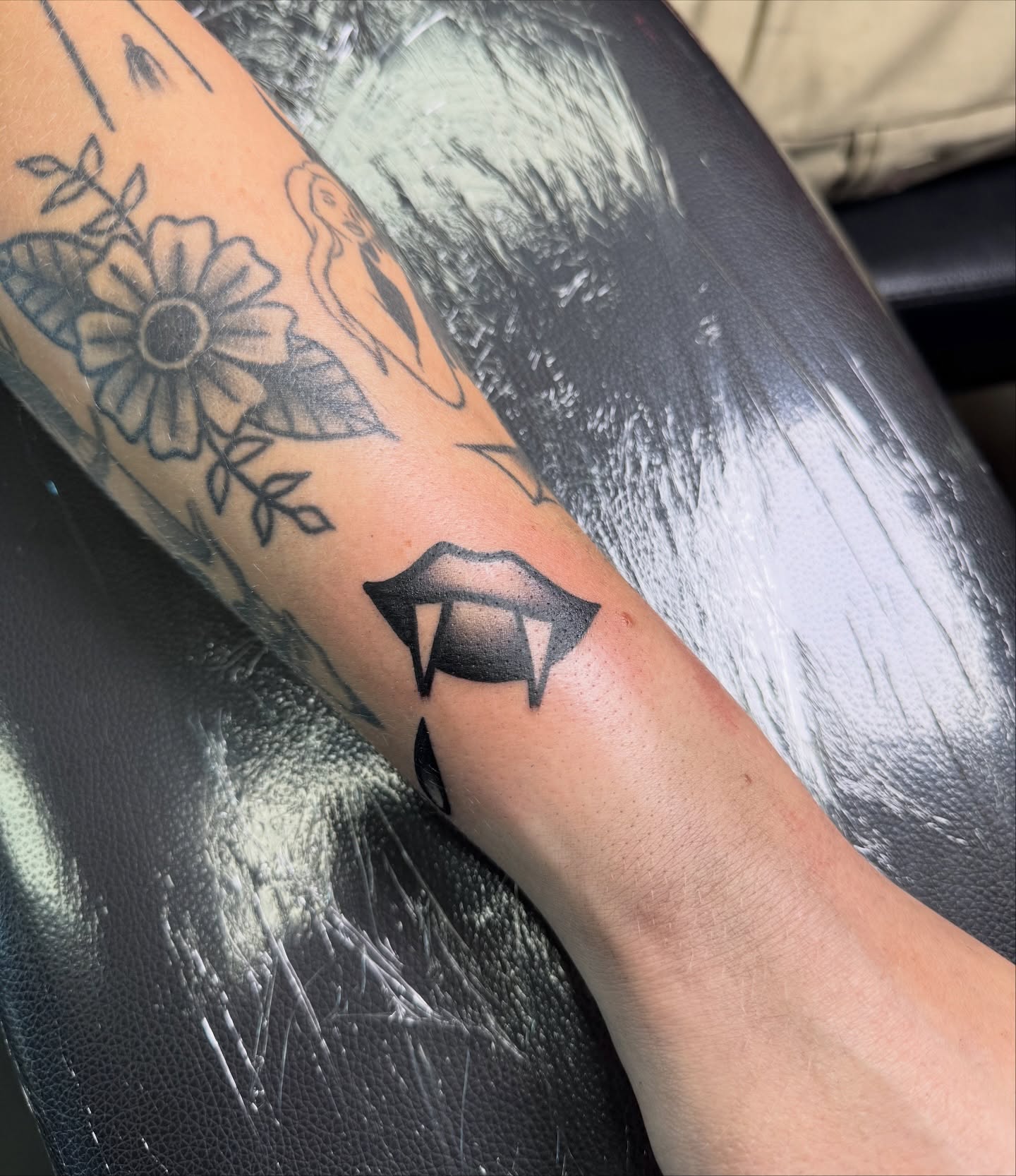 Lips black and grey tattoo on the forearm by Ryland - Tattoo Artist