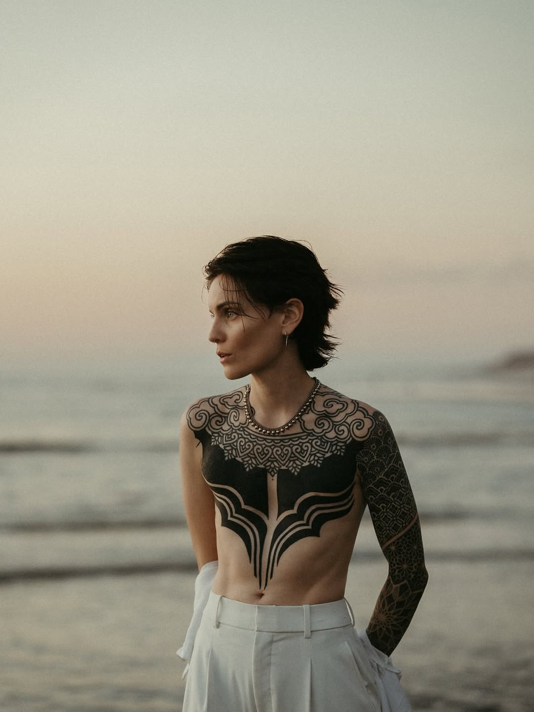 Ornamental chest and arm tattoo tribal tattoo on the torso by Storm Smith