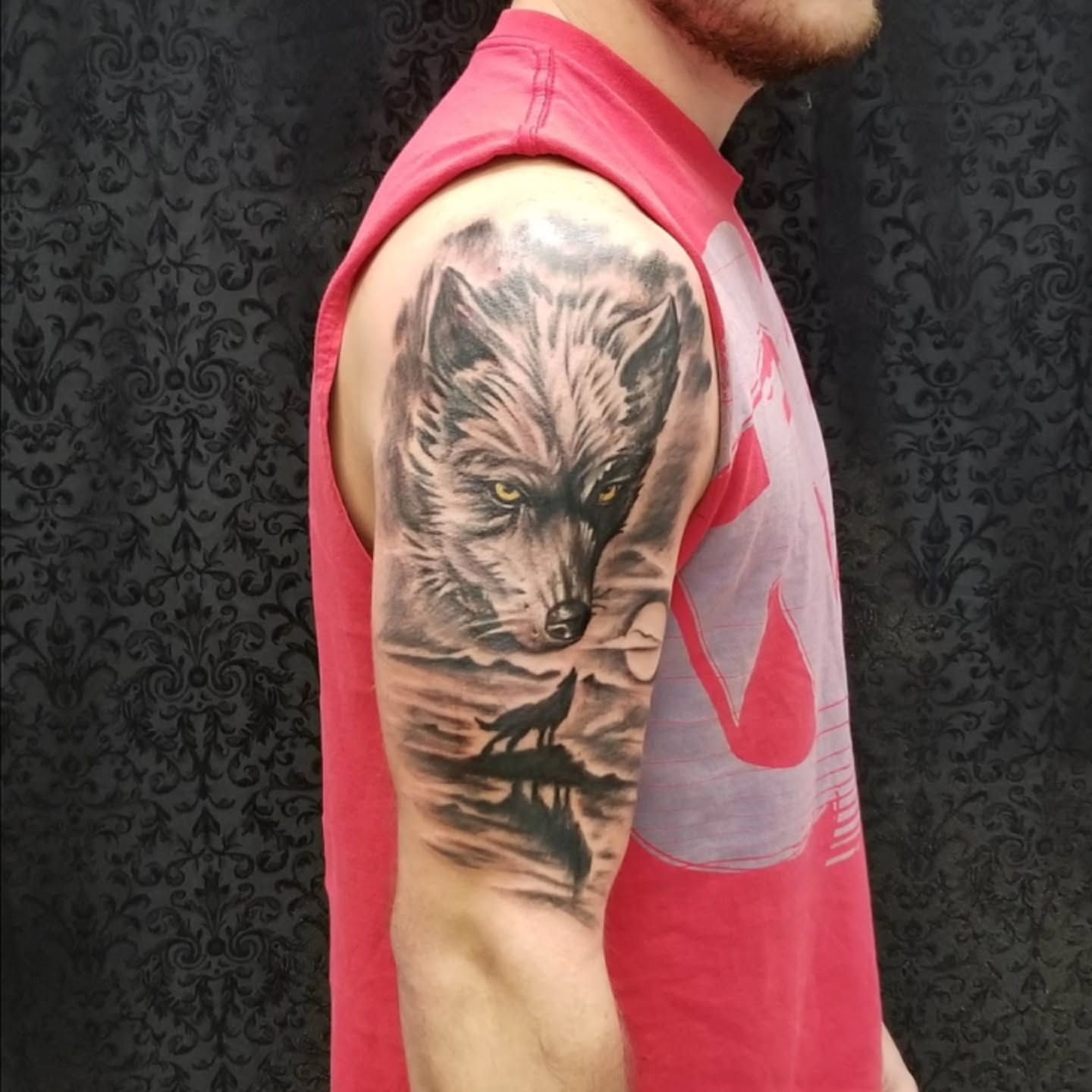 Wolf realism tattoo on the upper arm by Dennis Foust