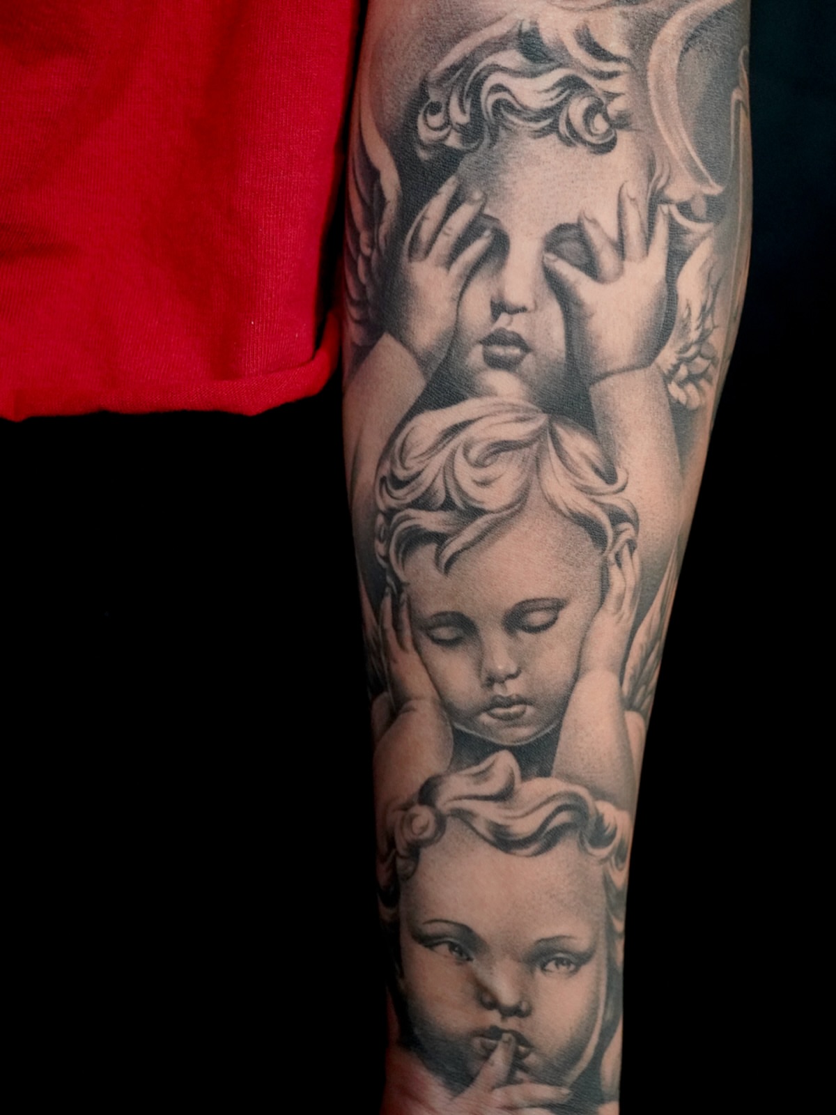 Cherubs realism tattoo on the forearm by tombstone