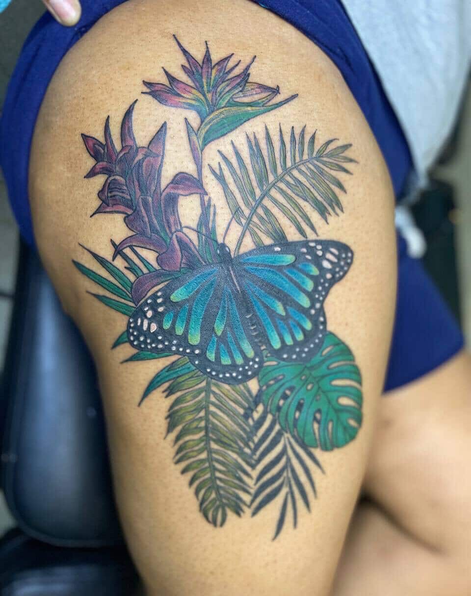 Butterfly and tropical foliage dotwork tattoo on the thigh by Zen Forbes