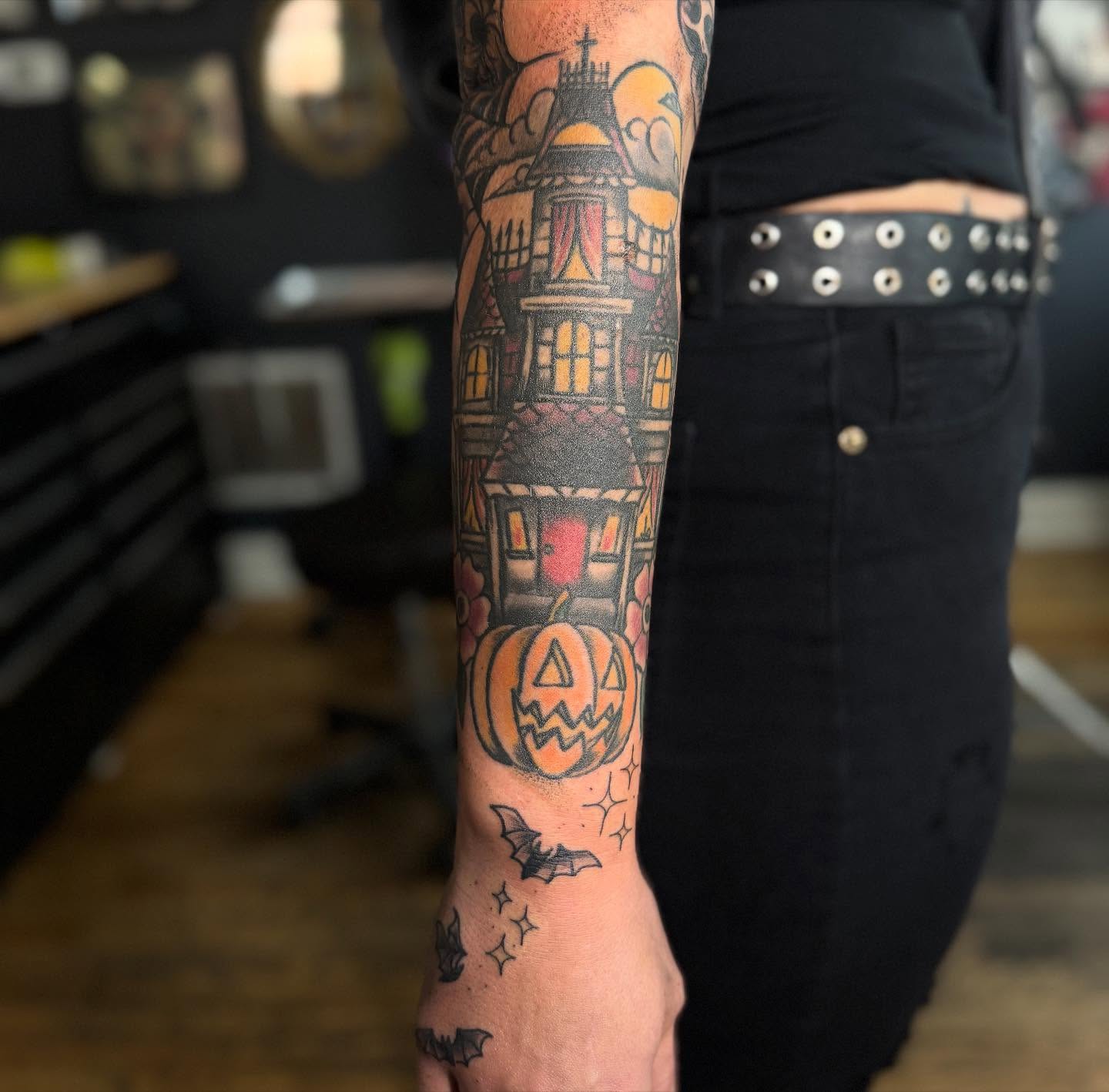 Haunted house and jack-o'-lantern American traditional tattoo on the forearm by Eric James, Columbus, Ohio