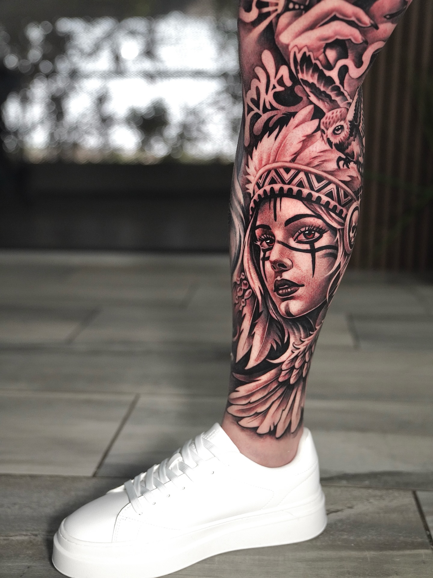 Woman with feather headdress realism tattoo on the forearm by Artem Kunakuzin