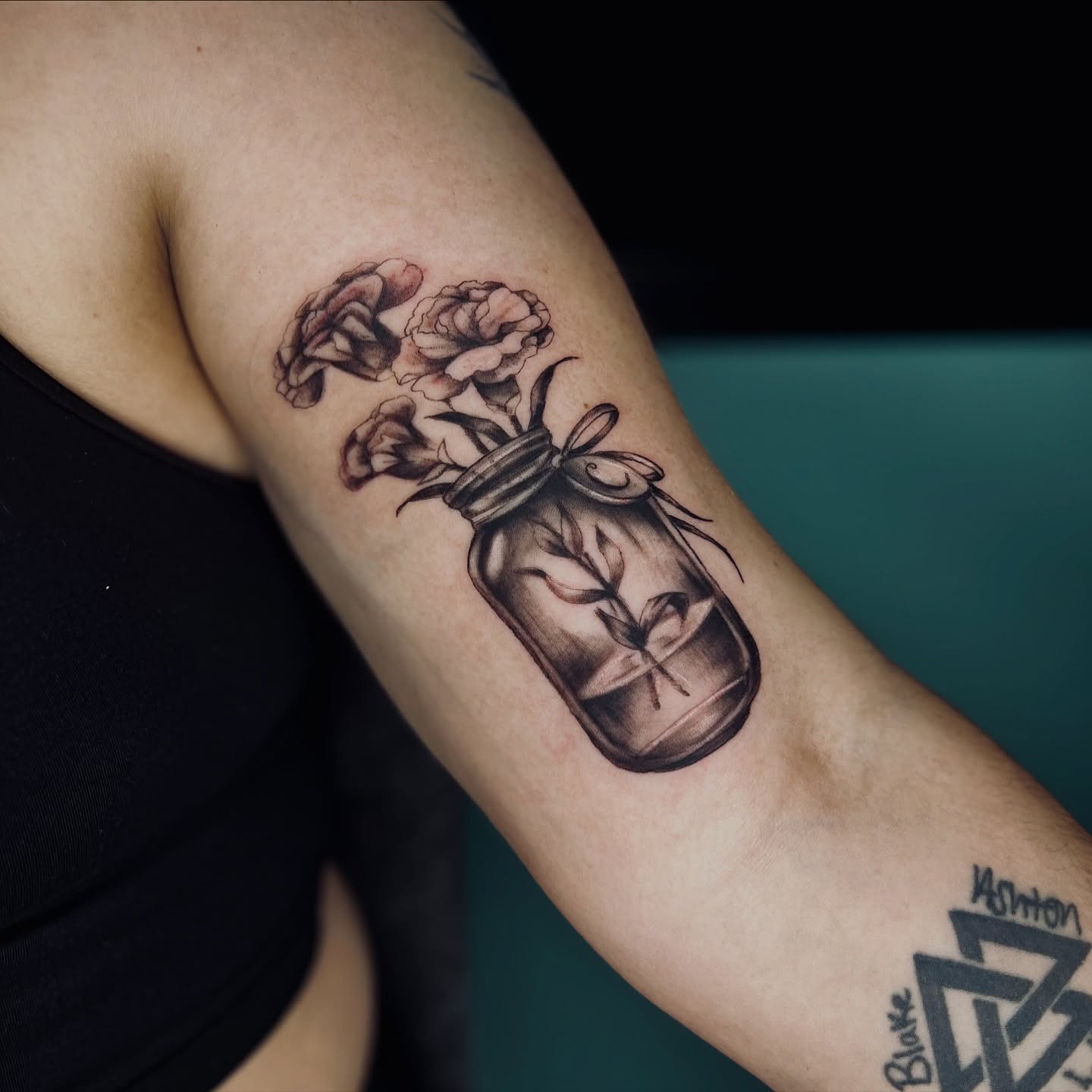Flowers in a jar black and grey tattoo on the forearm by Sydney Rose