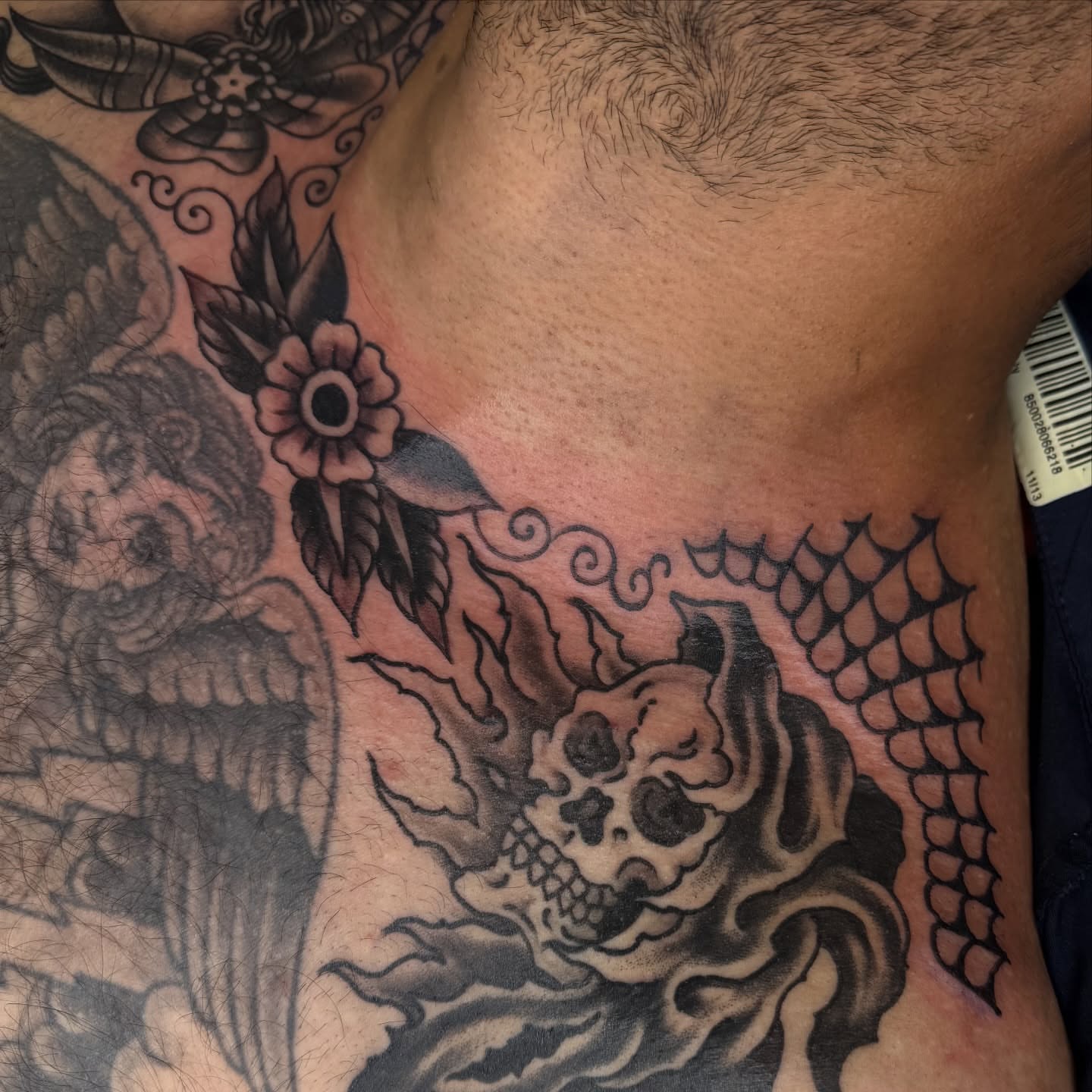 Skull and flames American traditional tattoo on the chest by Ben Karnofsky
