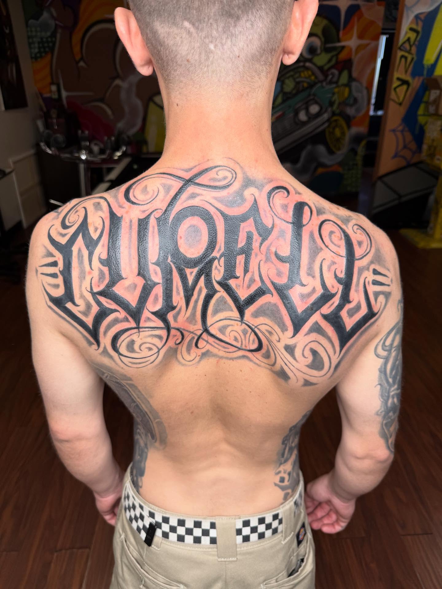 Script lettering lettering script tattoo on the back by Las Vegas Tattoo Artist
