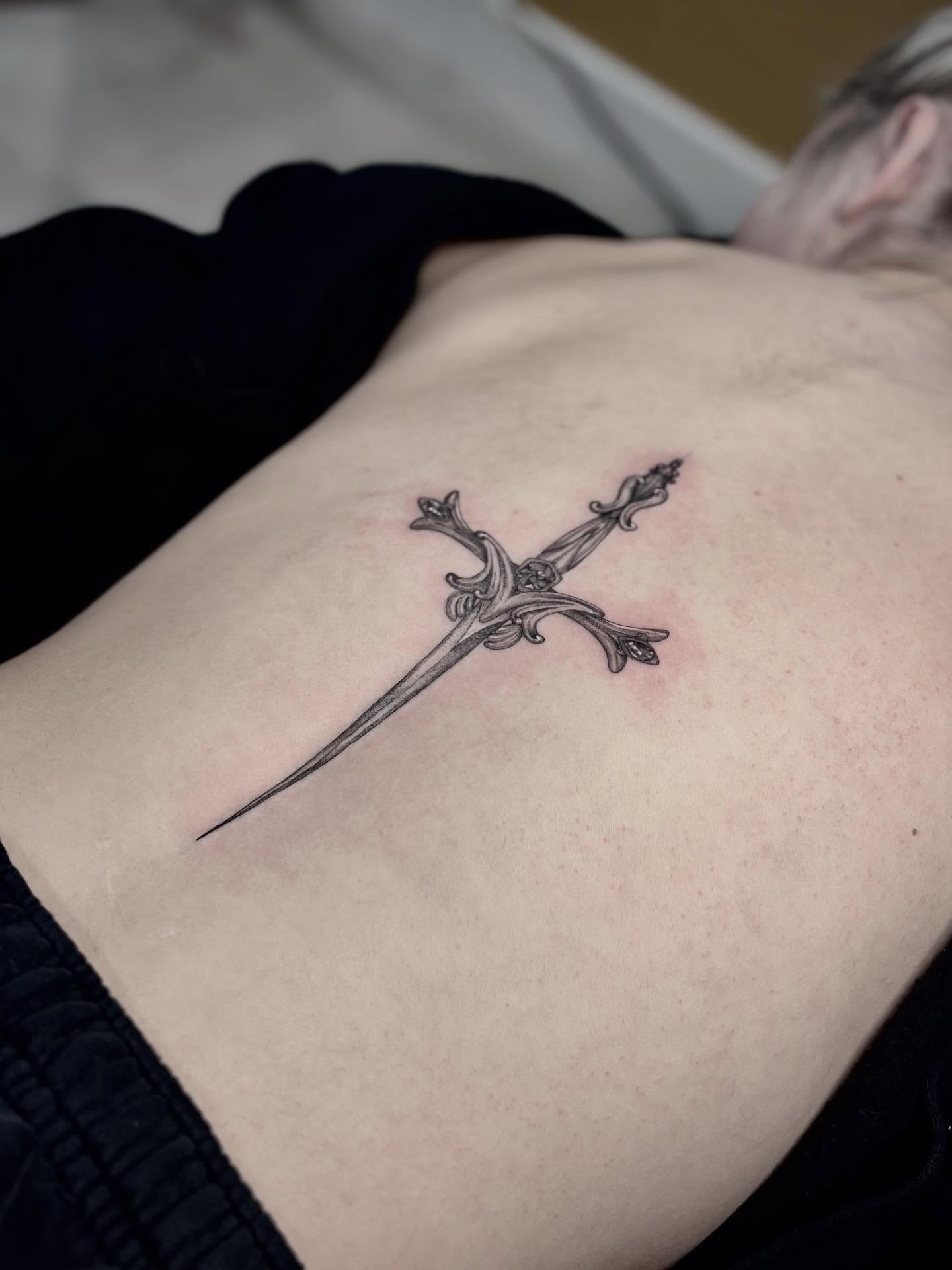 Sword black and grey tattoo on the back by Jazzlyn Hous