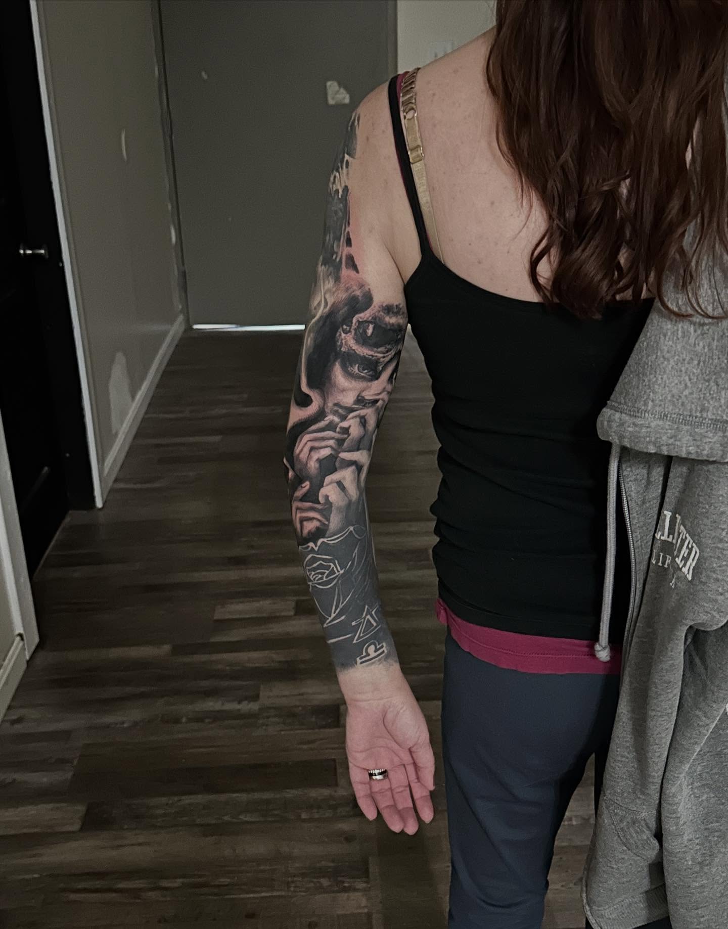 Man with mask realism tattoo on the upper arm by Neil5one3