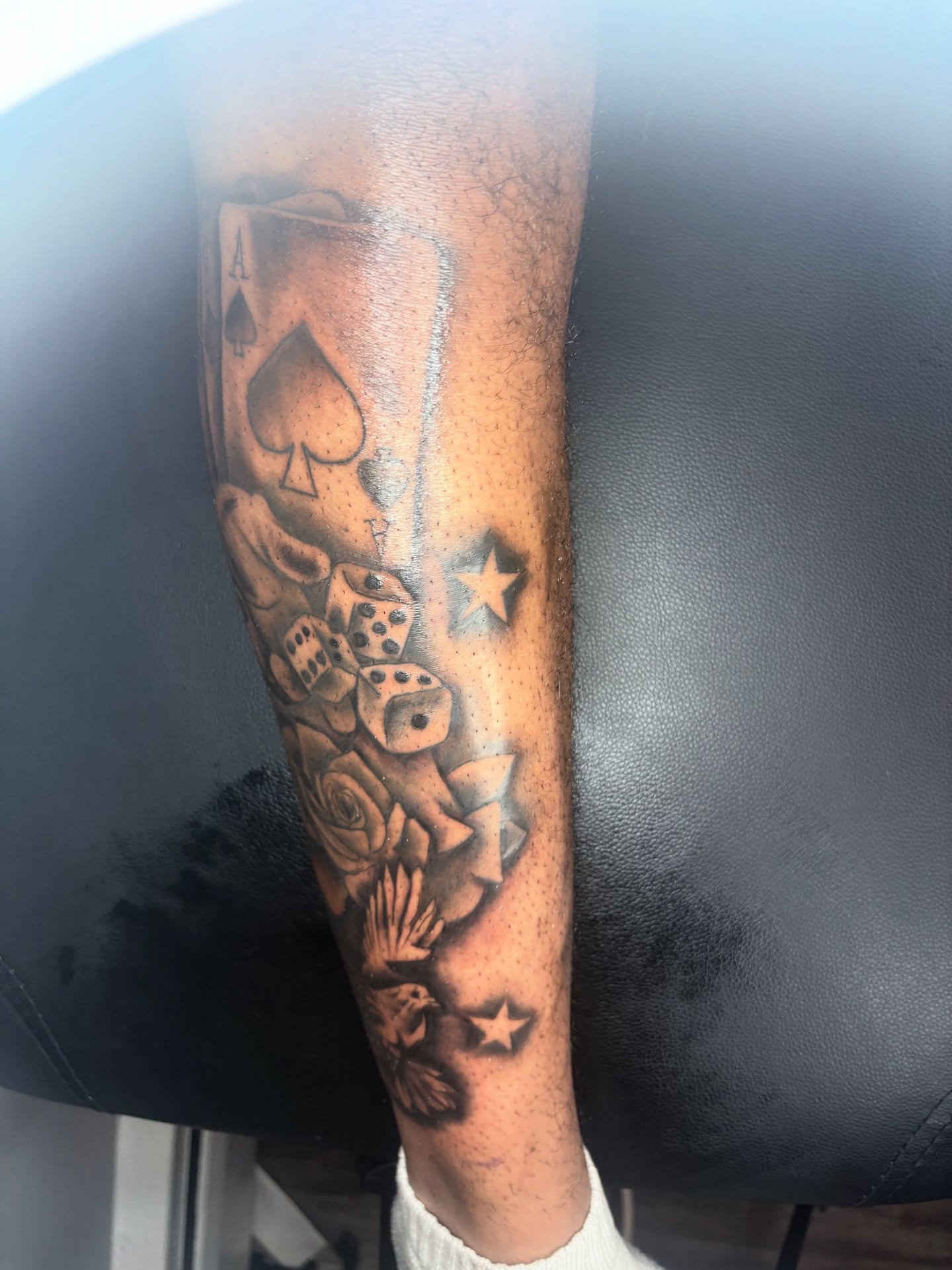 Playing cards and dice American traditional tattoo on the forearm by Maleek Inkz