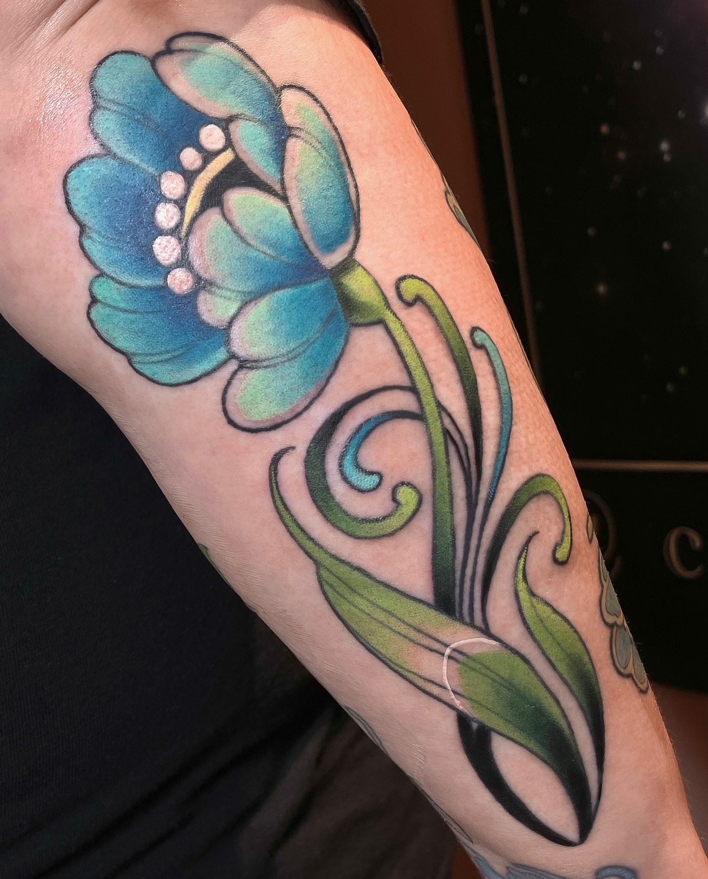 Blue poppy American traditional tattoo on the forearm by Corra Carmine