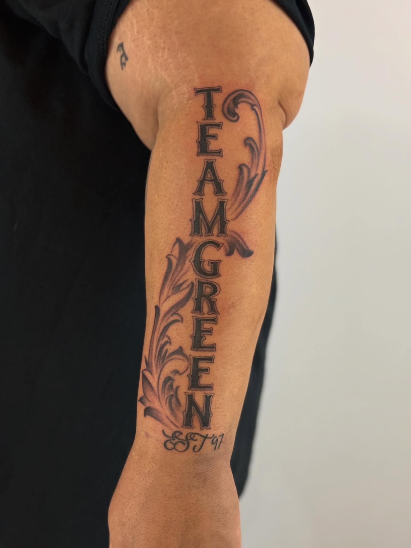 Team green black and grey tattoo on the forearm by Paul Calhoun Tattoos, Englewood, Ohio