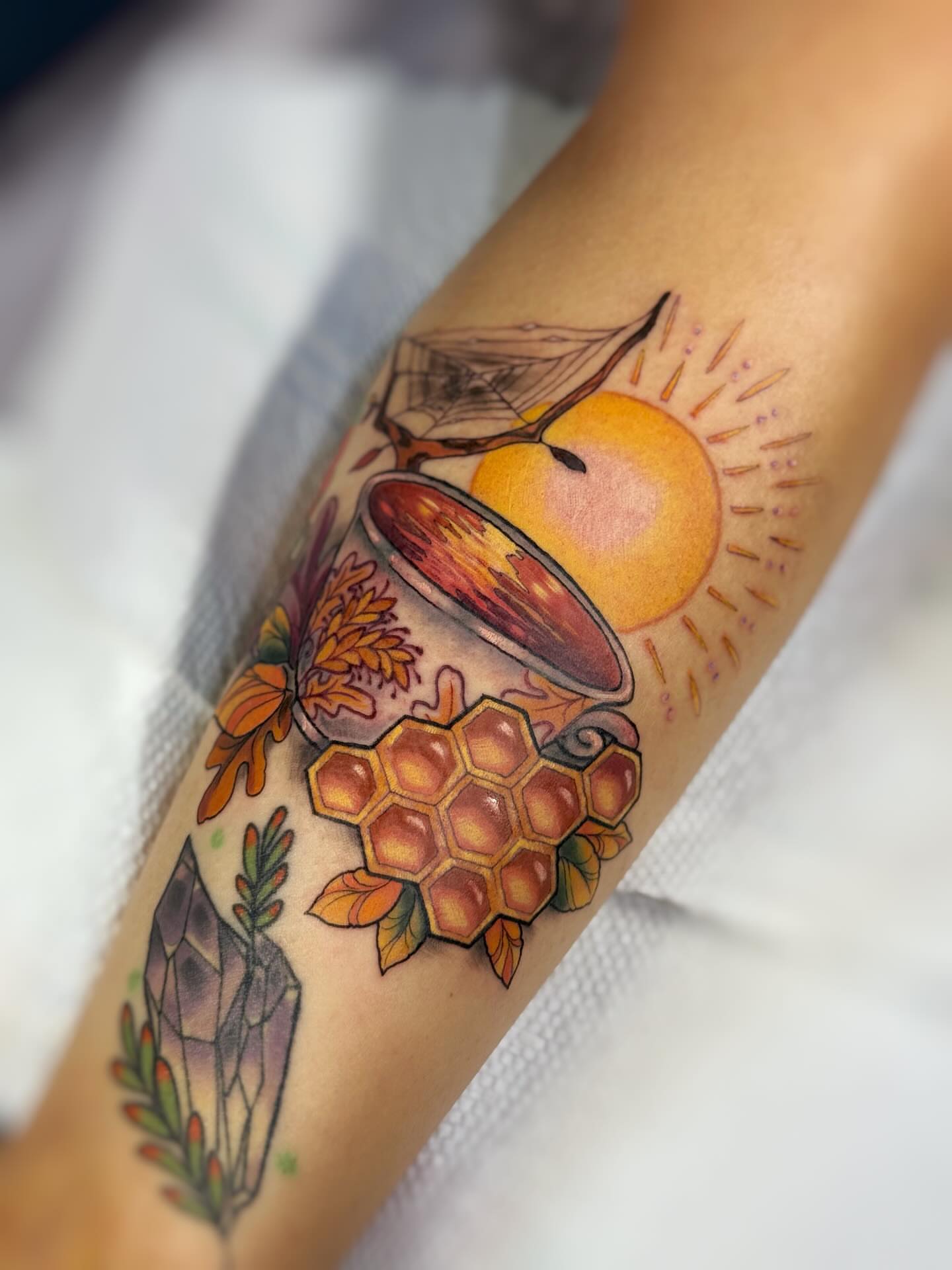 Honeycomb and sun geometric tattoo on the forearm by Anna Saveria