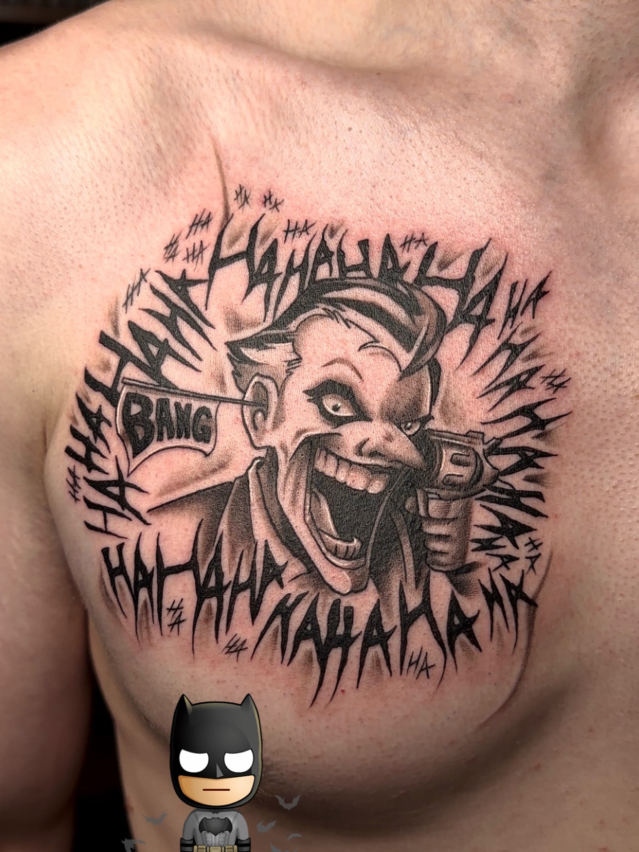 Joker laughing black and grey tattoo on the chest by Denis Seregin
