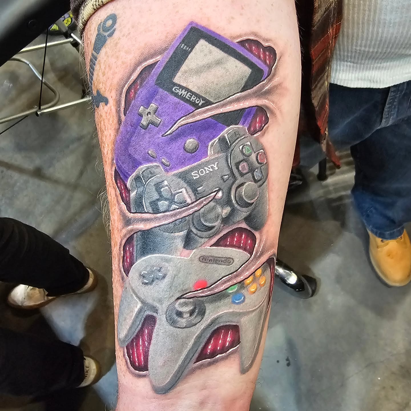 Video game controllers realism tattoo on the forearm by Derek Davis