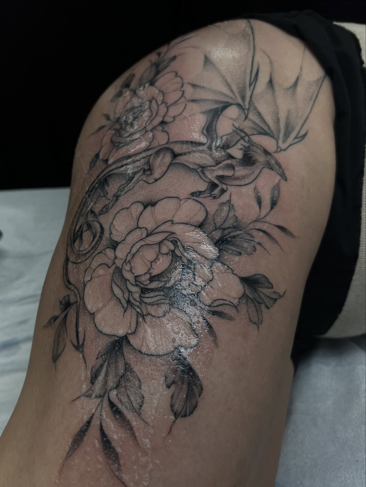 Floral bouquet black and grey tattoo on the thigh by Chloe