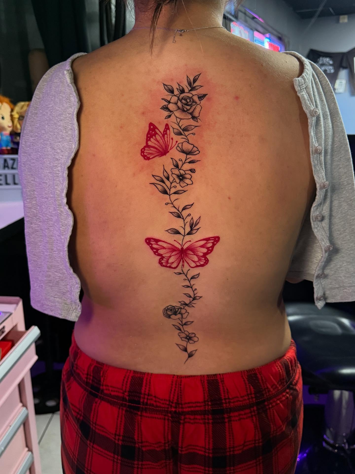 Butterfly and floral vine neo-traditional tattoo on the back by Jasmin Lozano