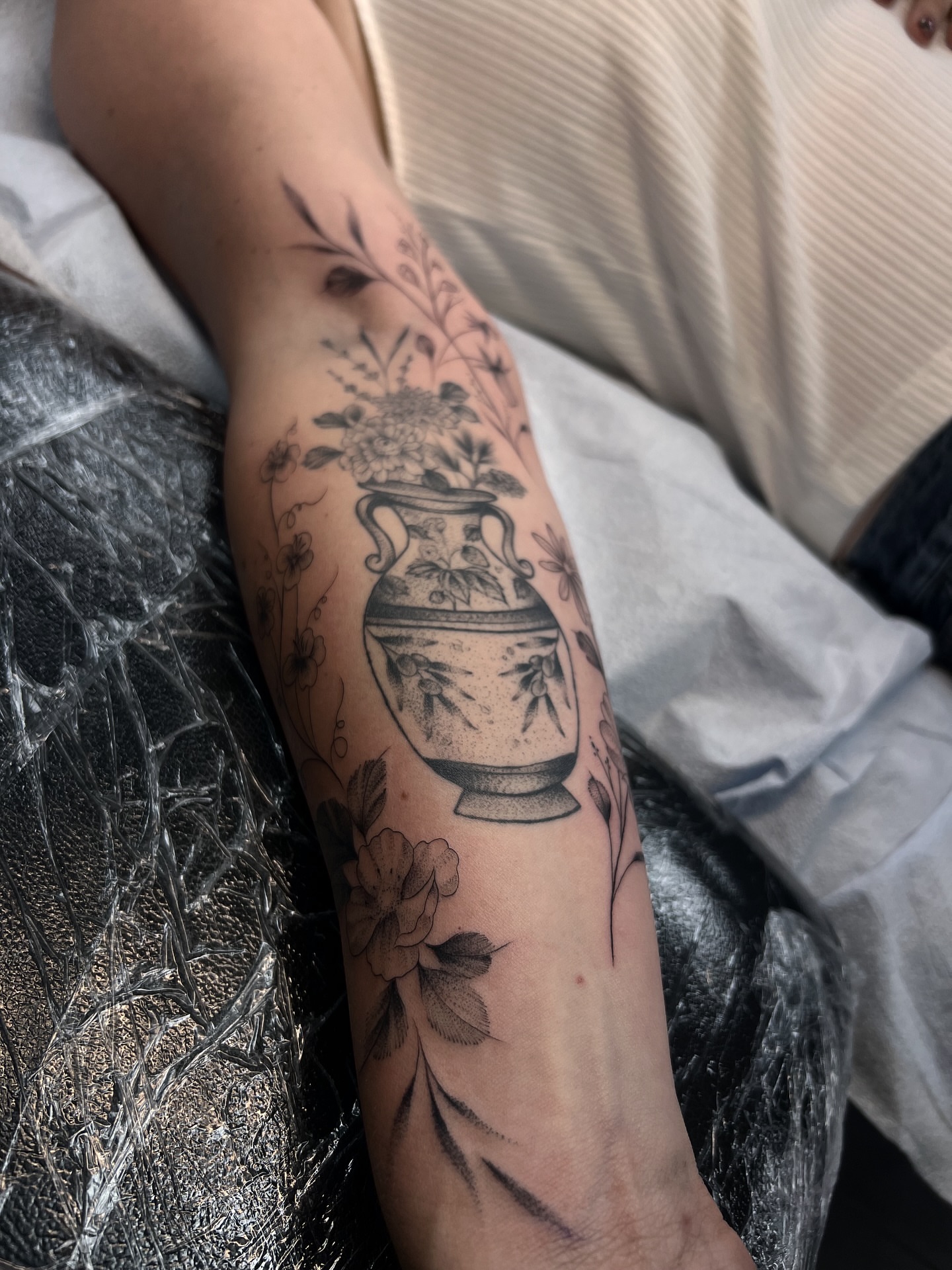 Urn with flowers black and grey tattoo on the forearm by Chloe