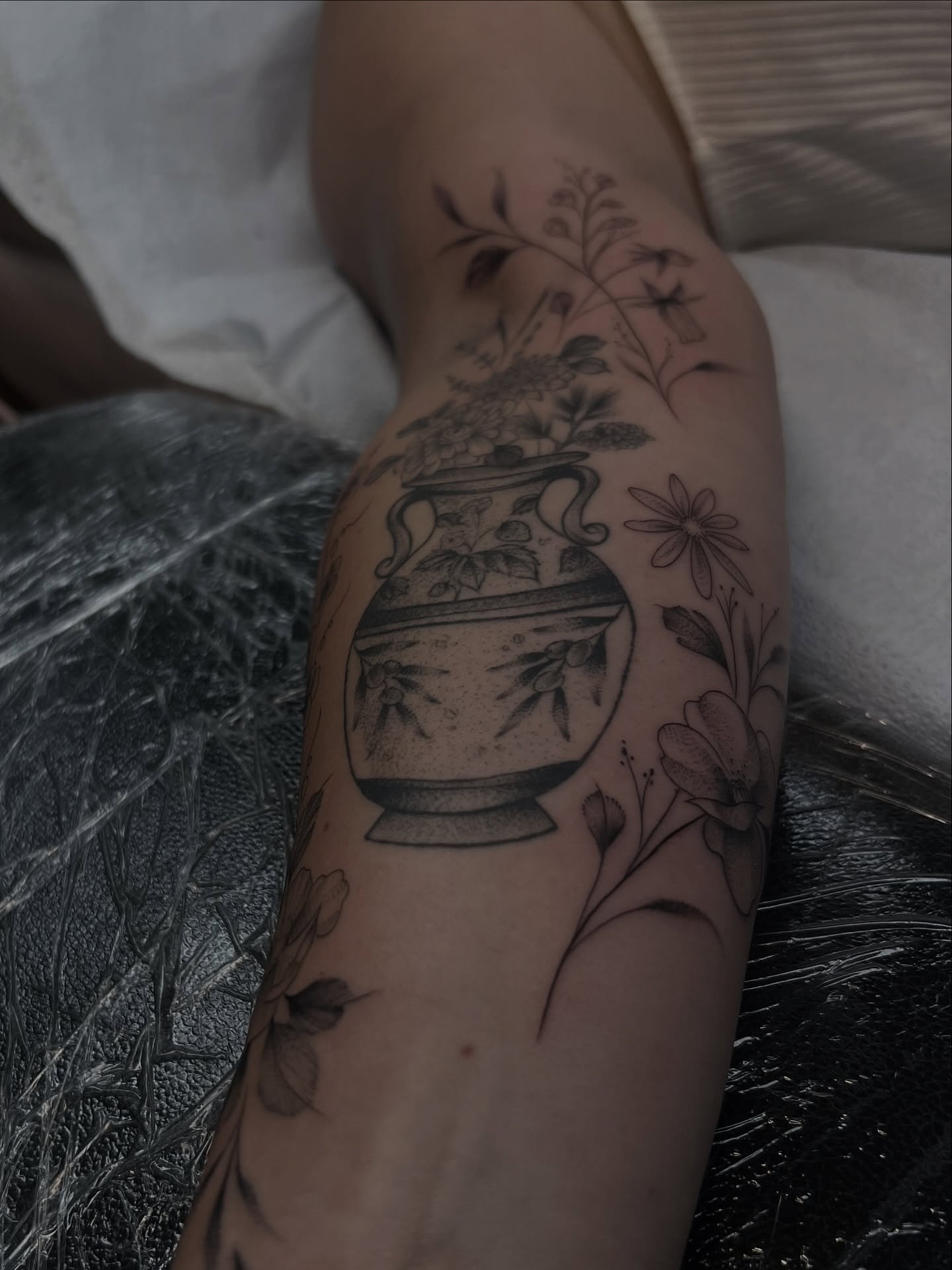 Urn with flowers black and grey tattoo on the forearm by Chloe