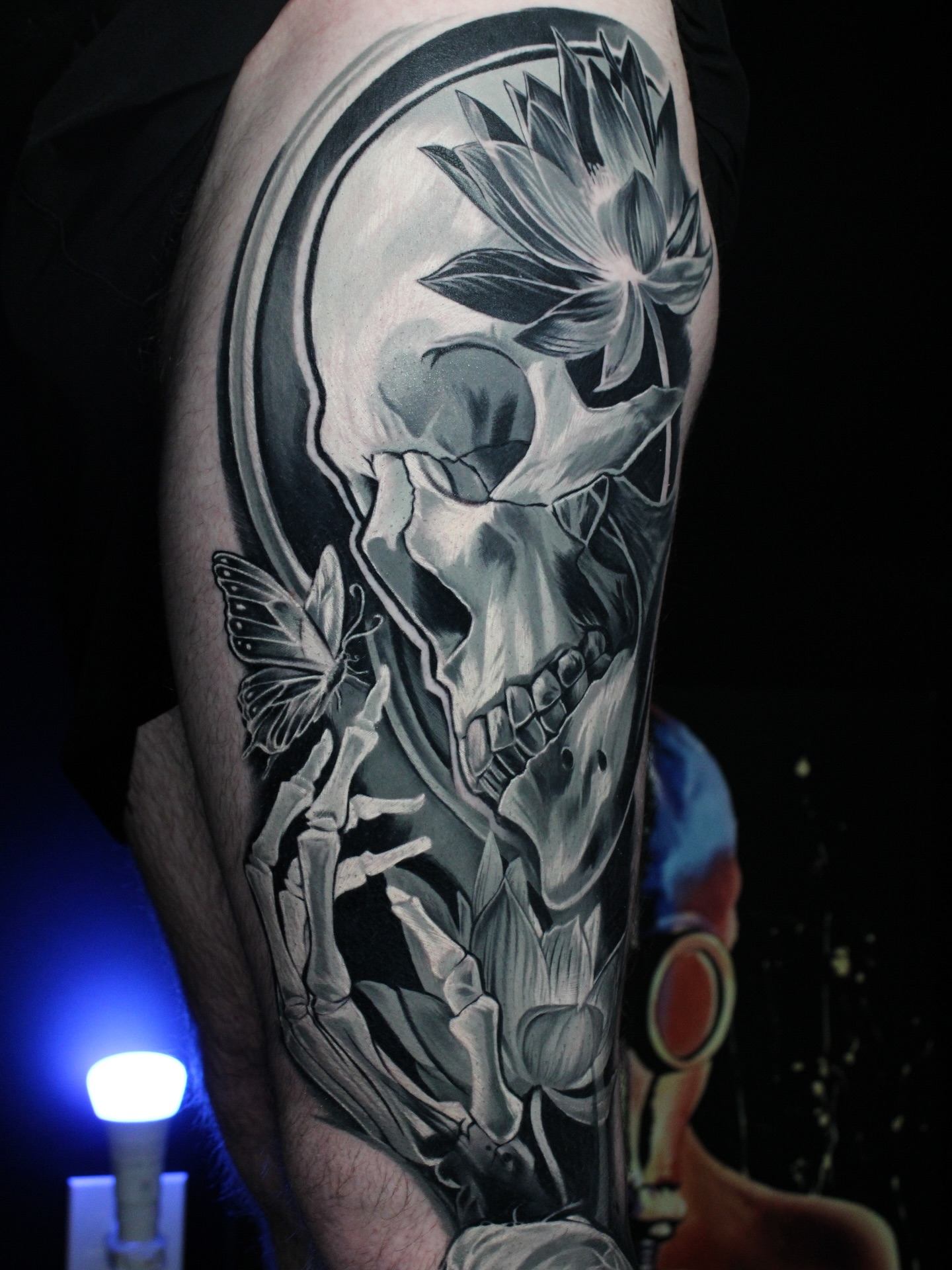 Skull and lotus realism tattoo on the forearm by Eva Williams