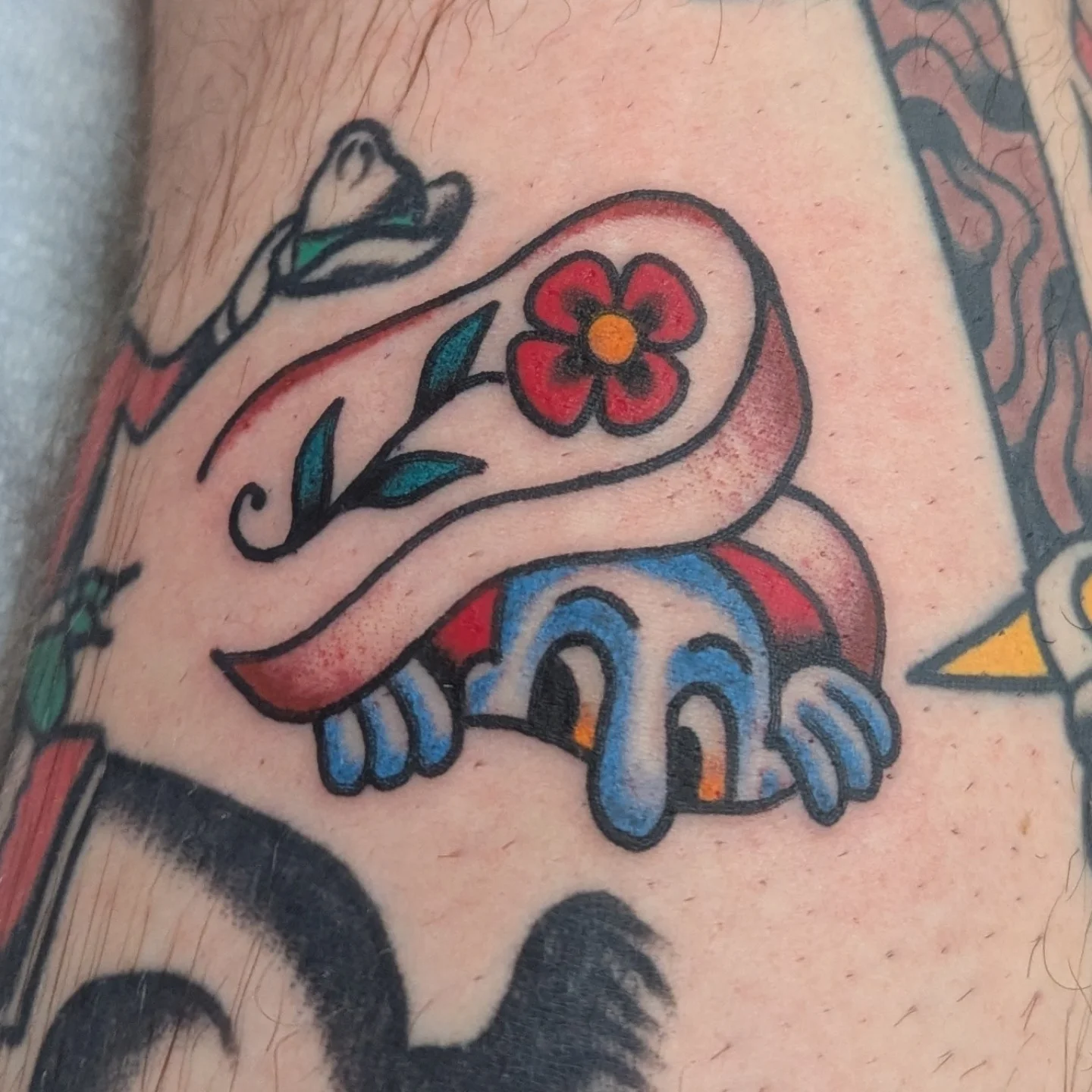 Frog with flower American traditional tattoo on the forearm by Zack Mueller