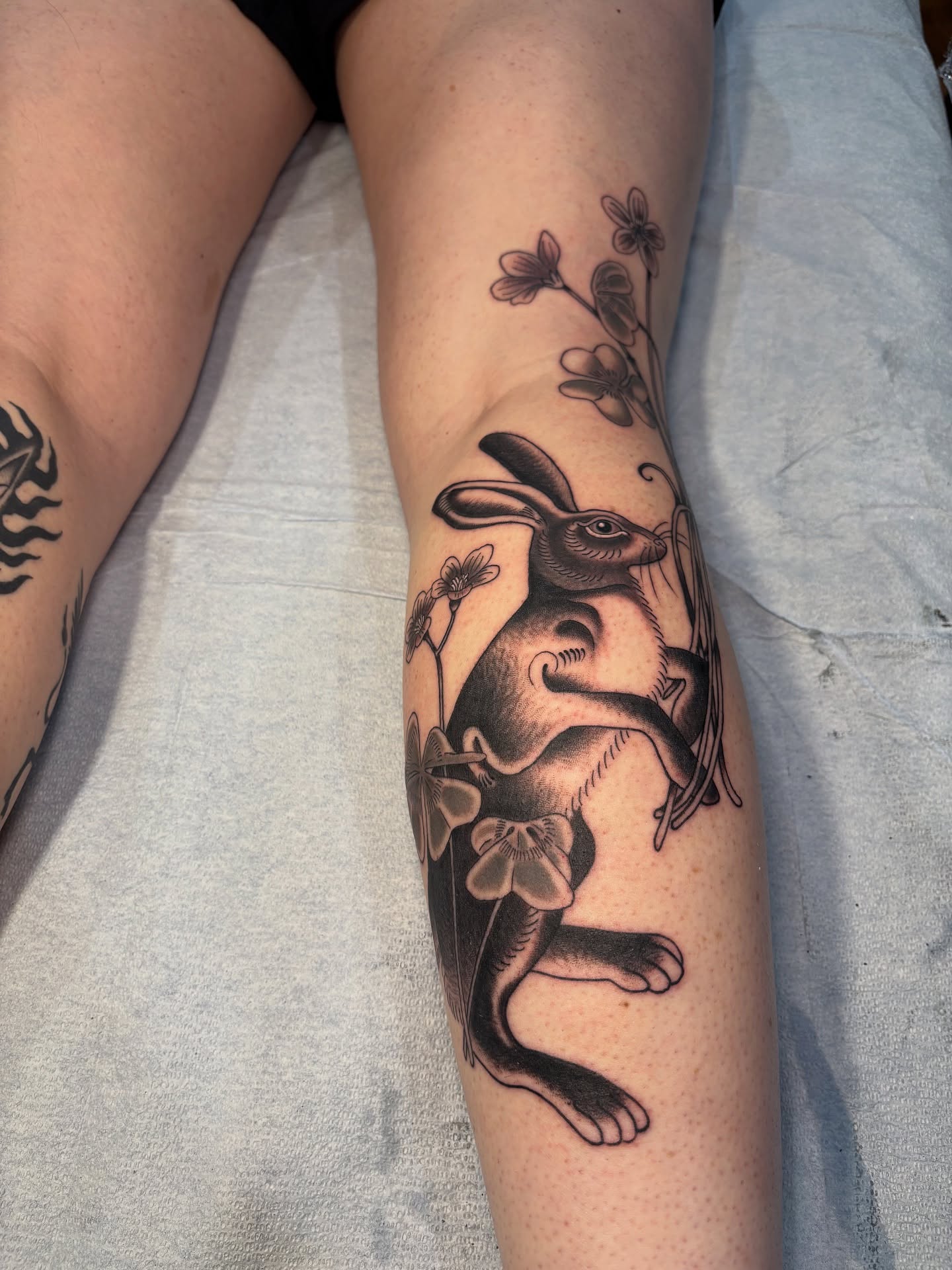Rabbit with flowers black and grey tattoo on the forearm by 𝓰𝓲𝓷𝓪 𝓼𝓮𝓻𝓹𝓮𝓷𝓽𝓲𝓷𝓪
