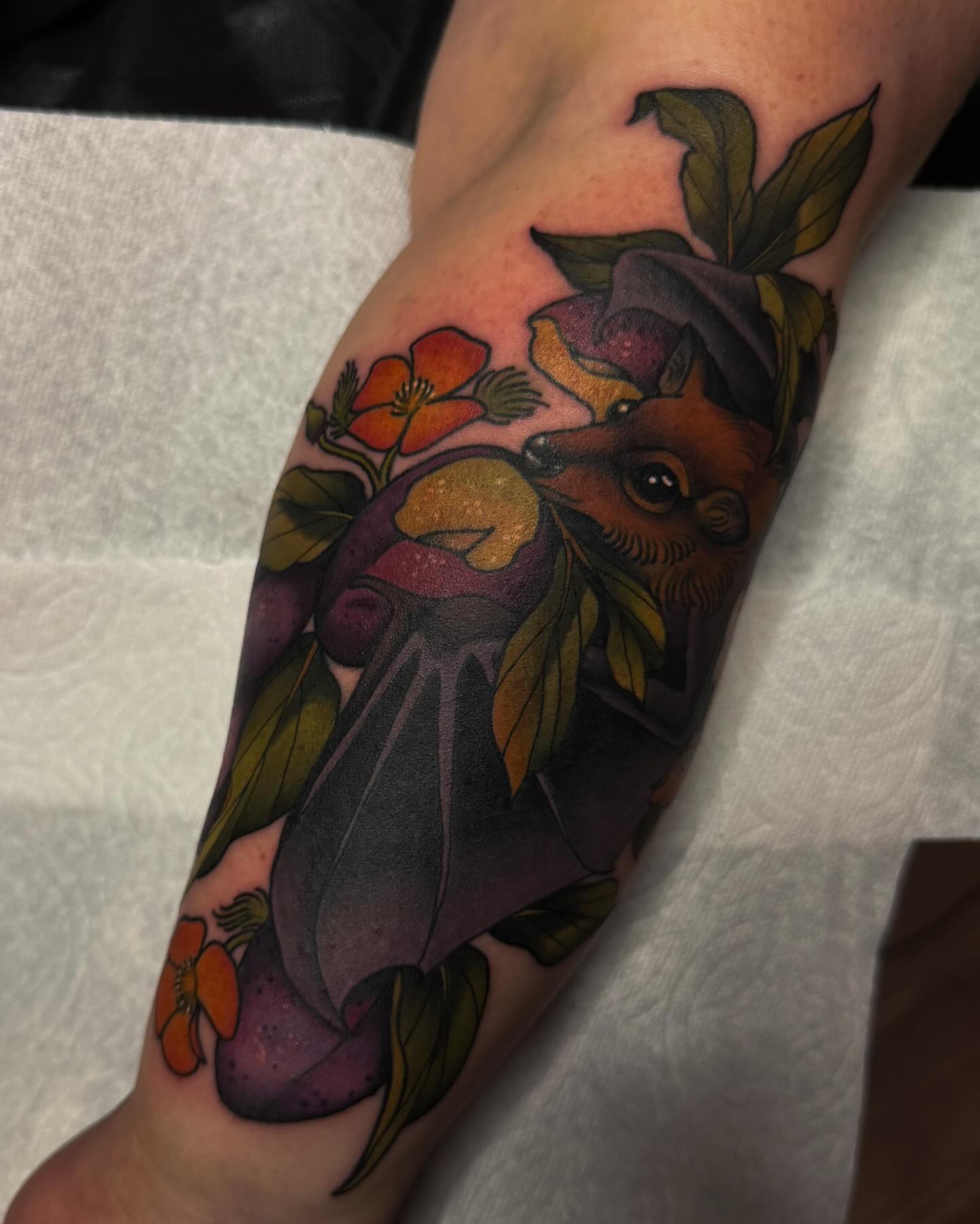 Bat and flowers American traditional tattoo on the forearm by Monica Amneus