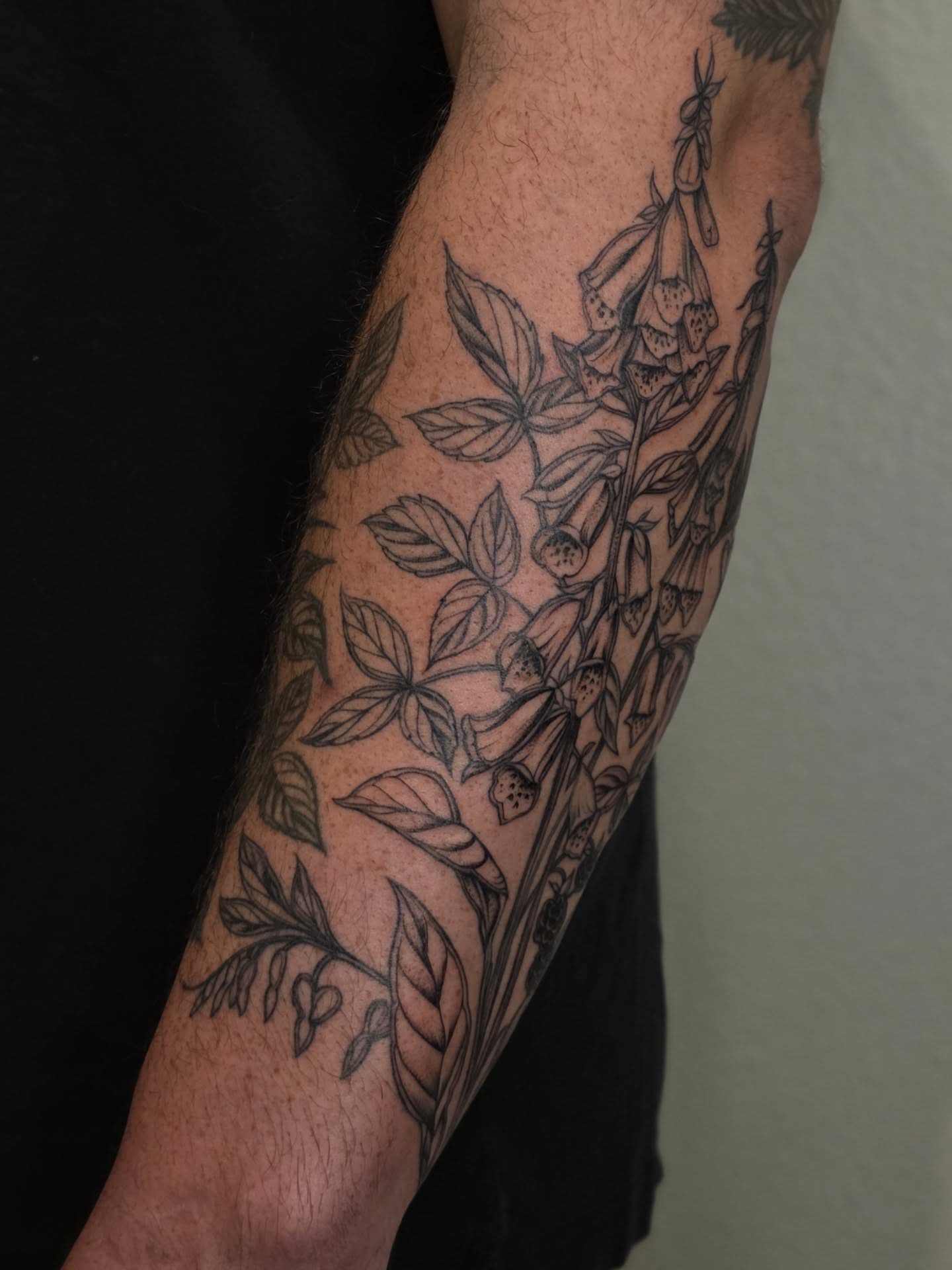 Foxglove plant black and grey tattoo on the forearm by Sierra (cc) Klein