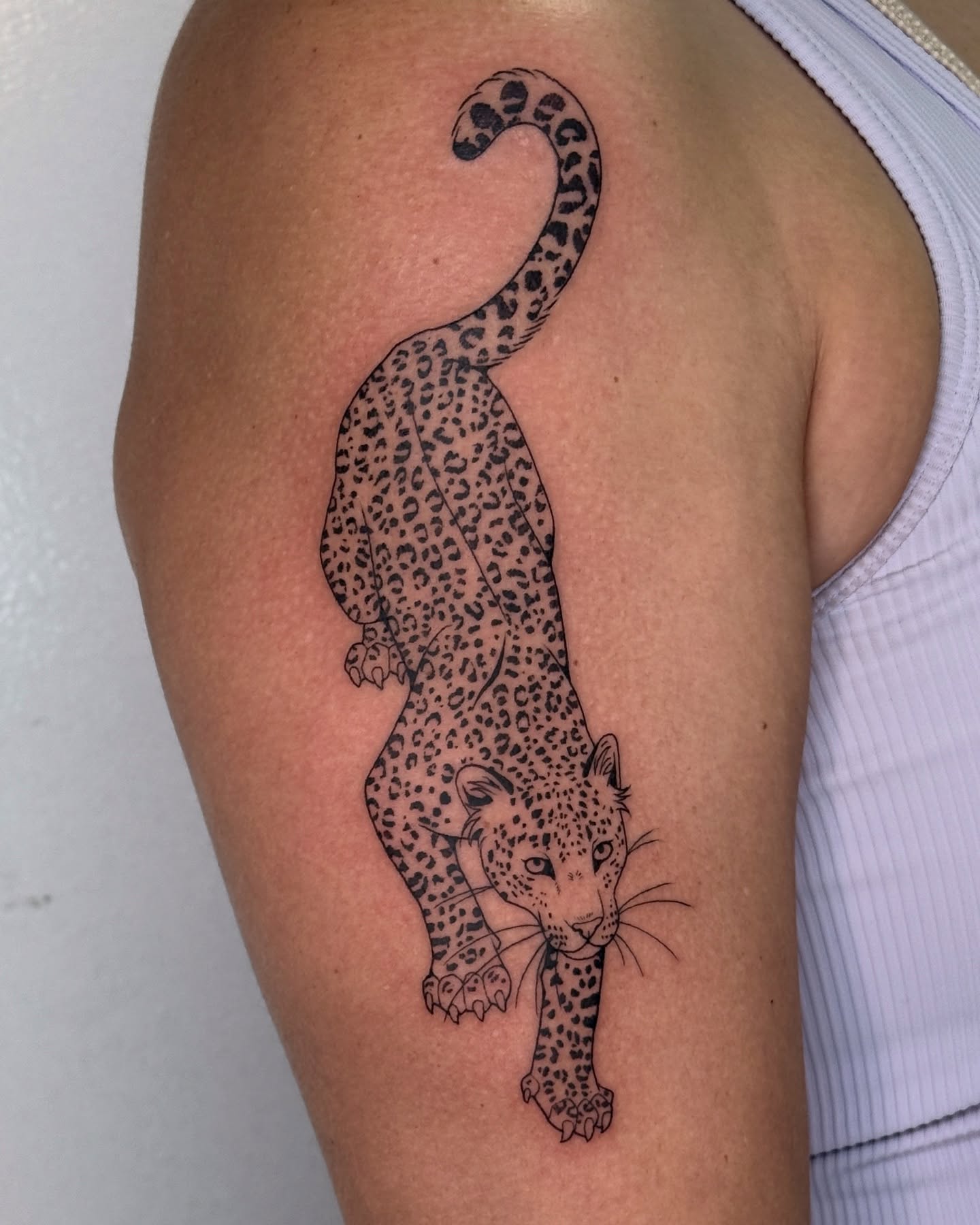 Leopard black and grey tattoo on the upper arm by Connor🍄🏳️‍⚧️