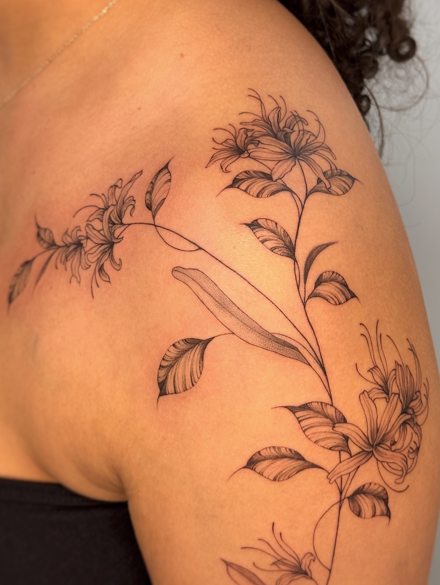 Floral arrangement black and grey tattoo on the shoulder by Gianna Rodriguez