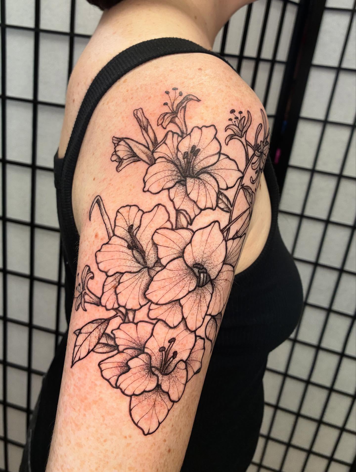 Lilies black and grey tattoo on the upper arm by ๐๐ช๐๐ซ๐ก๐ ๐๐ฏ๐ถ๐ฉ๐