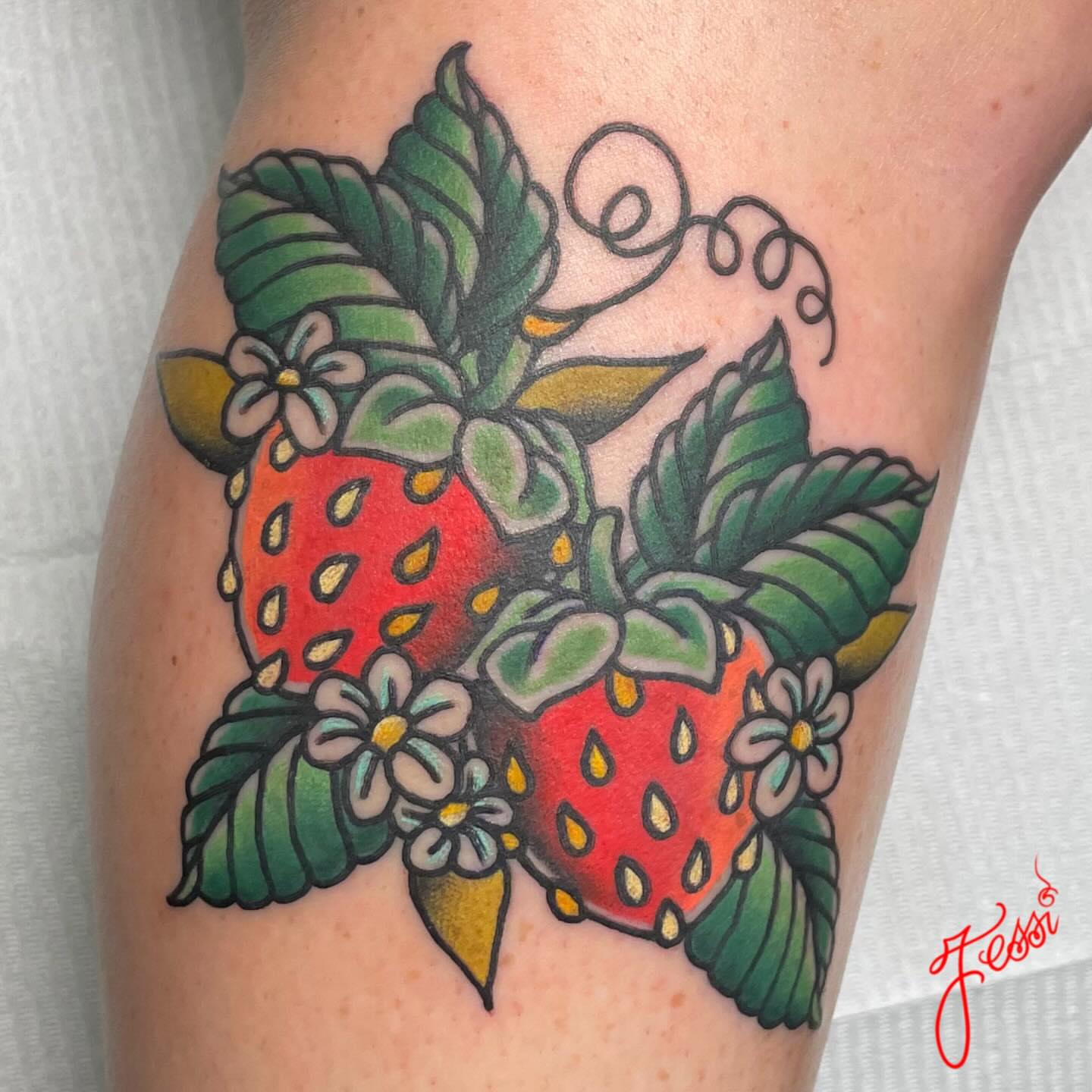 Strawberries and flowers American traditional tattoo on the forearm by Jessi Kilpatrick
