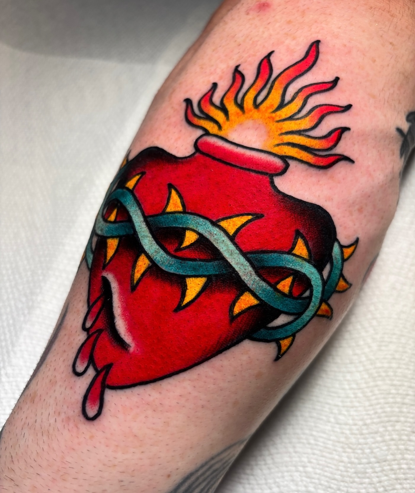 Heart with flames and infinity symbol American traditional tattoo on the forearm by Mickey Putillo, Charlotte, North Carolina