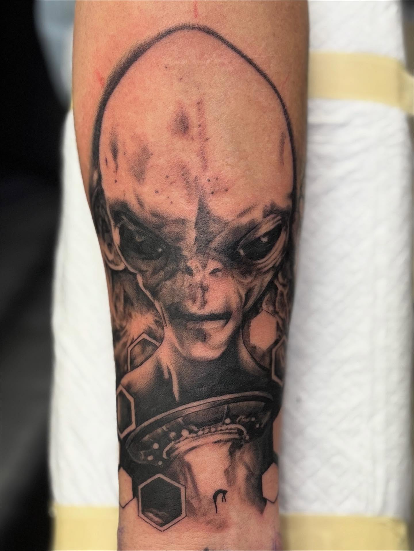 Alien head realism tattoo on the forearm by Amy Kolton