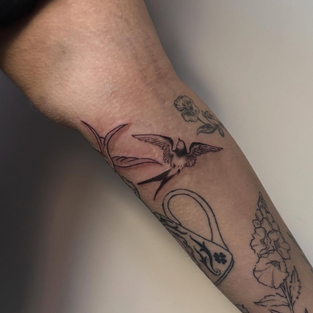 Swallow and leaves fine line tattoo on the forearm by Kirsten