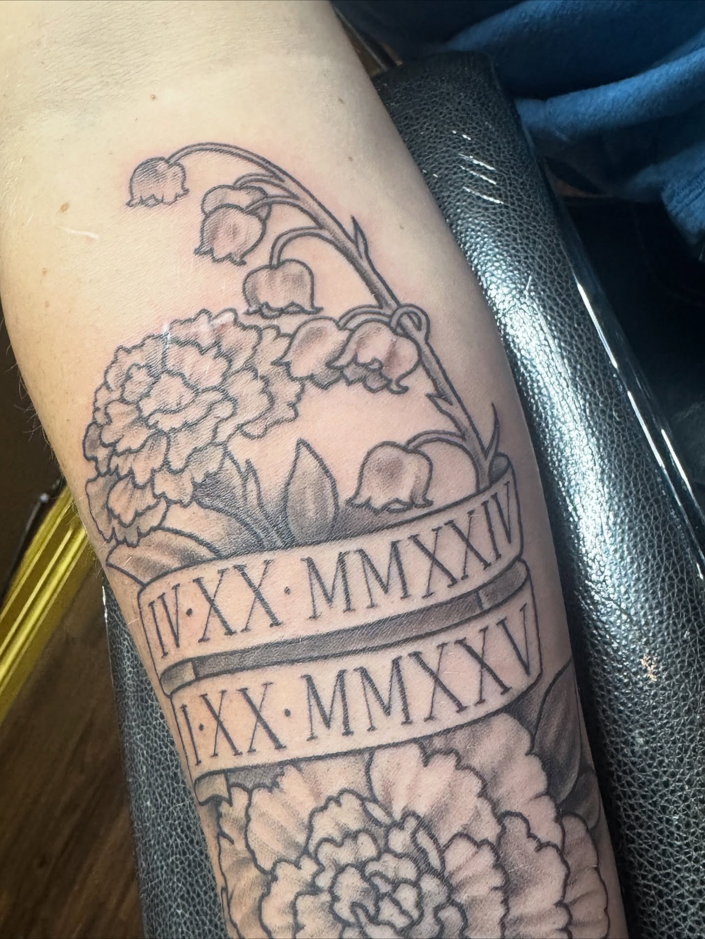 Lily of the valley and carnations black and grey tattoo on the forearm by Teagan Rachel, Millcreek, Utah