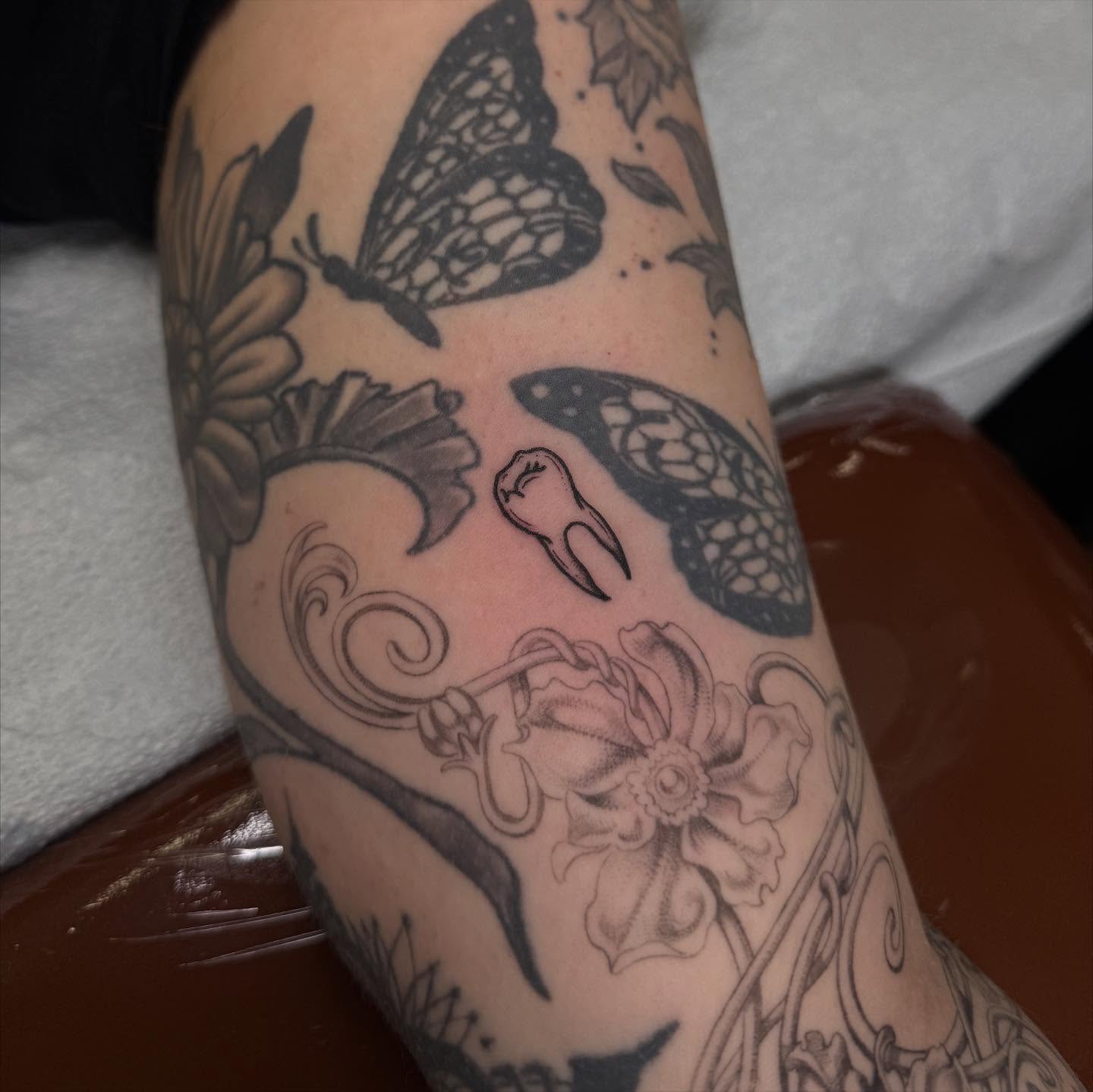 Butterflies and flowers black and grey tattoo on the forearm by Erin Shea