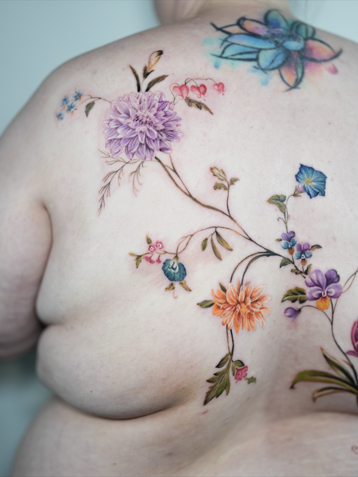 Floral arrangement watercolor tattoo on the back by Henry