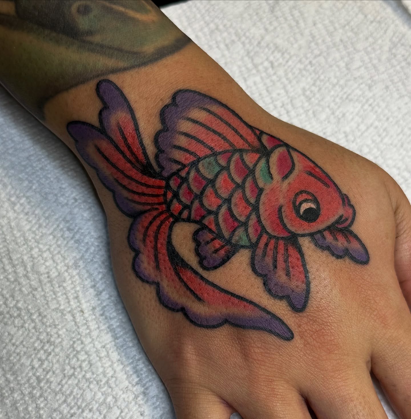 Goldfish American traditional tattoo on the hand by Amanda Bonhomme, Las Vegas, Nevada
