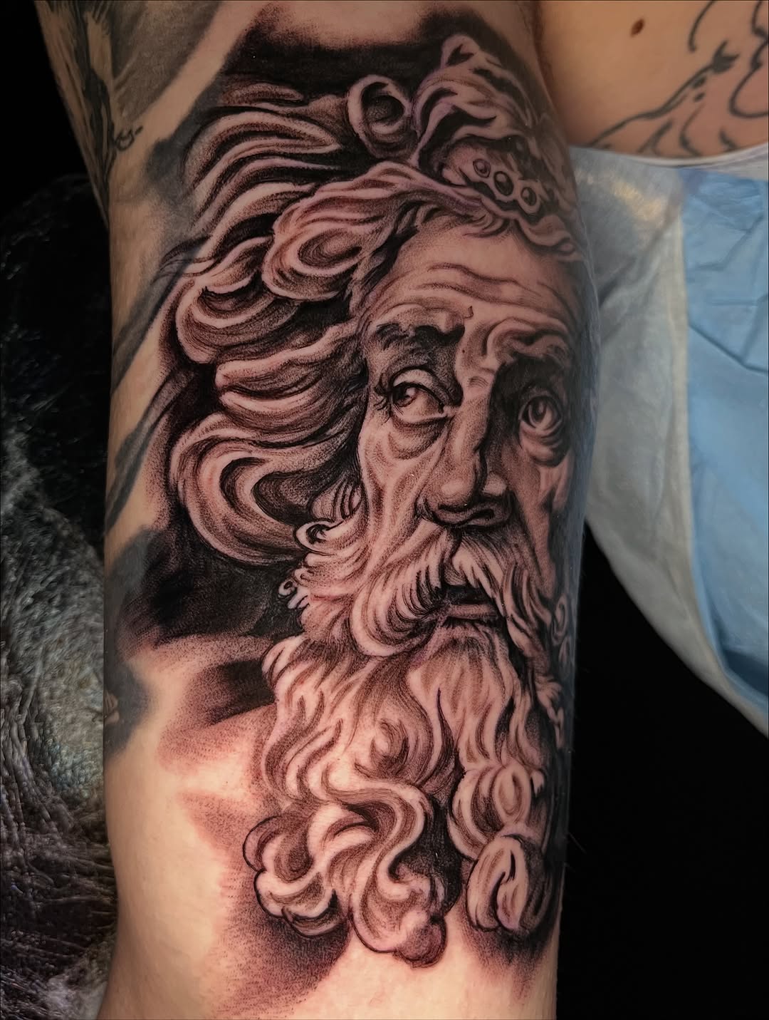 Bust of a bearded man surrealism tattoo on the forearm by "el asere, el zurdo"