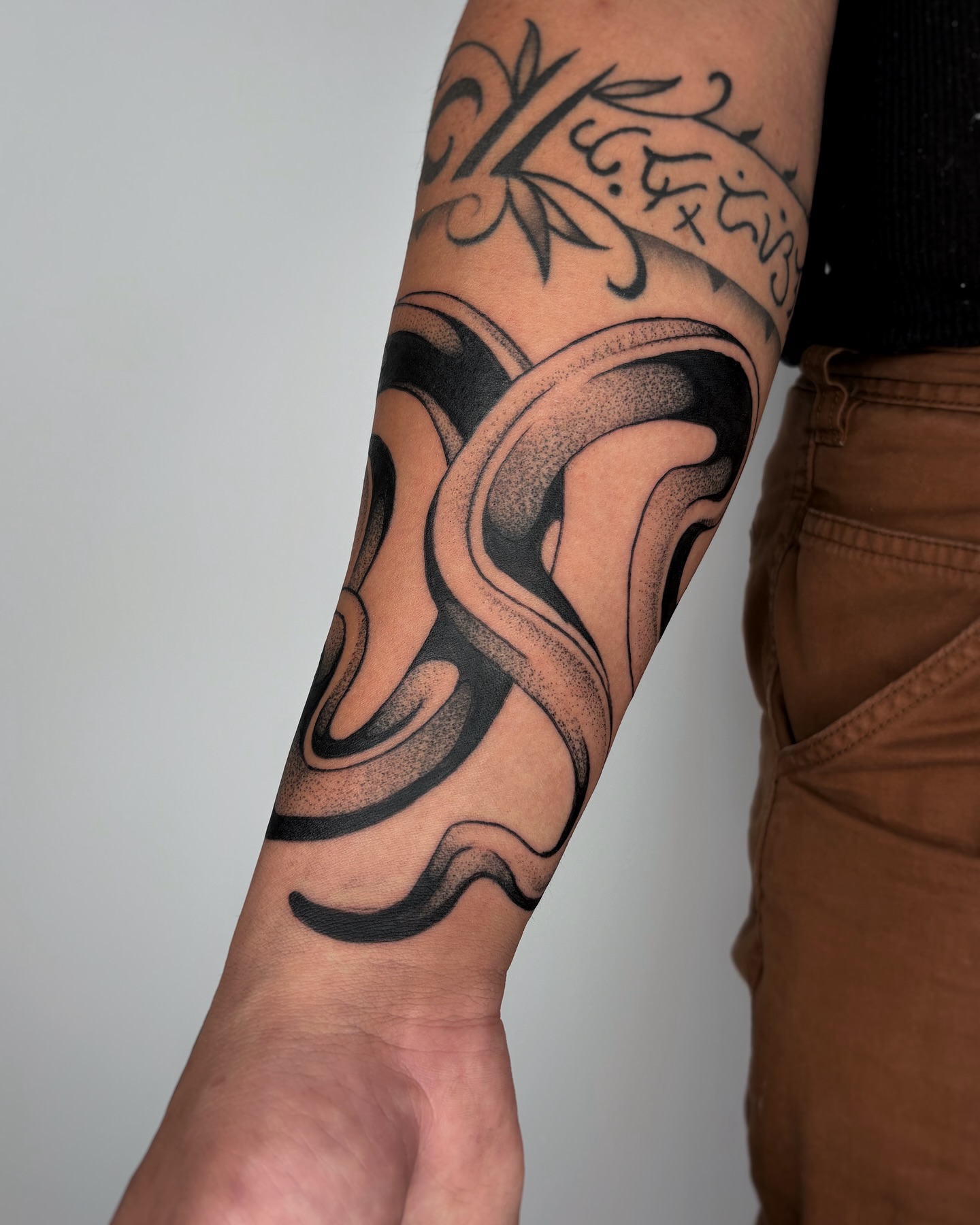 Abstract swirl dotwork tattoo on the forearm by Kuya, Berkeley, California