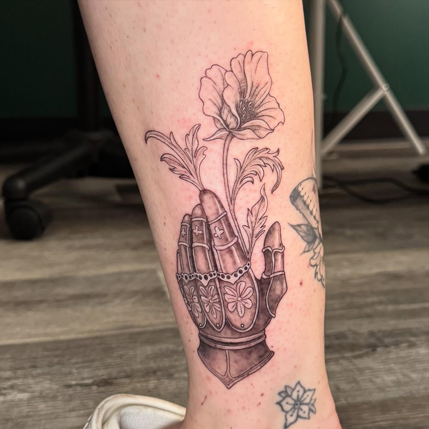 Praying hands with flower black and grey tattoo on the forearm by Leslea Hipp