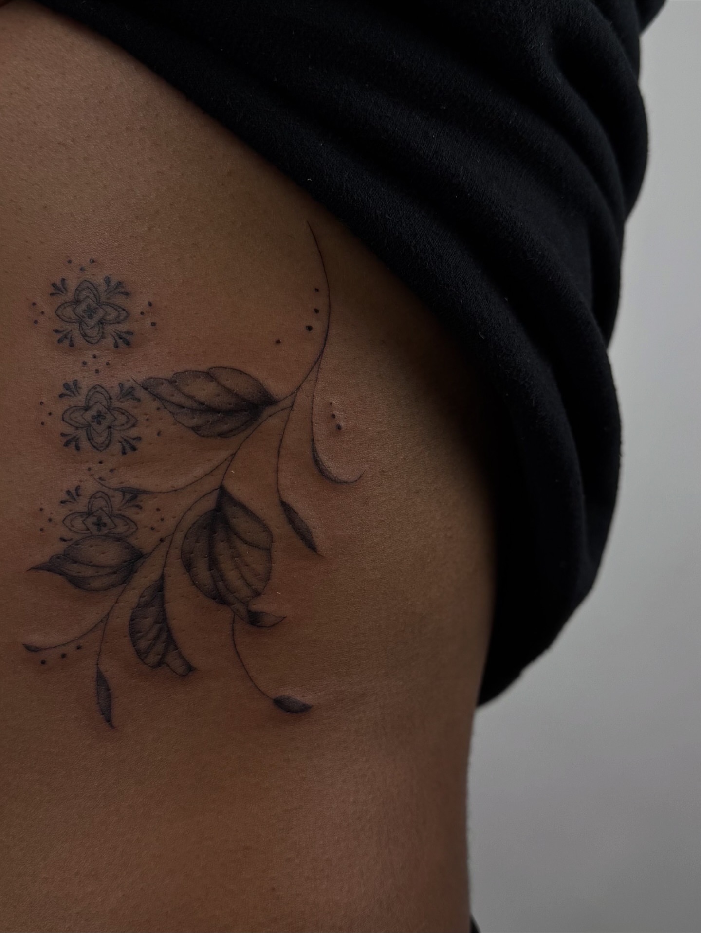 Floral branch black and grey tattoo on the thigh by sabina