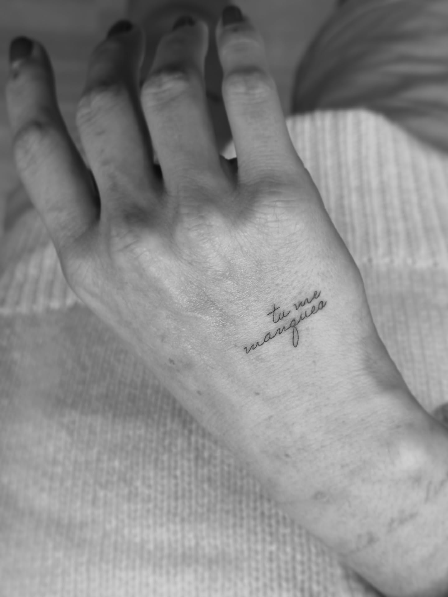 Tu me manques lettering script tattoo on the hand by Yuli Noama