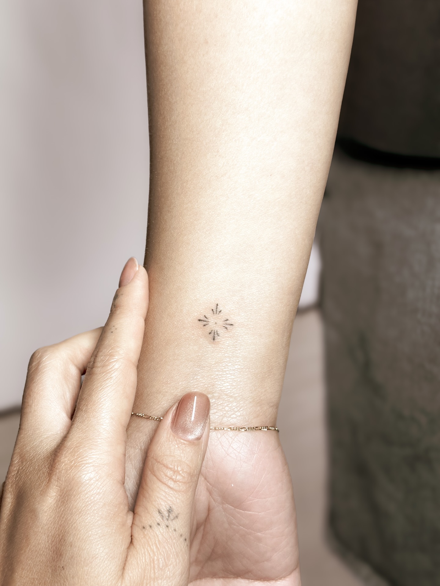 Starburst geometric tattoo on the forearm by Yuli Noama
