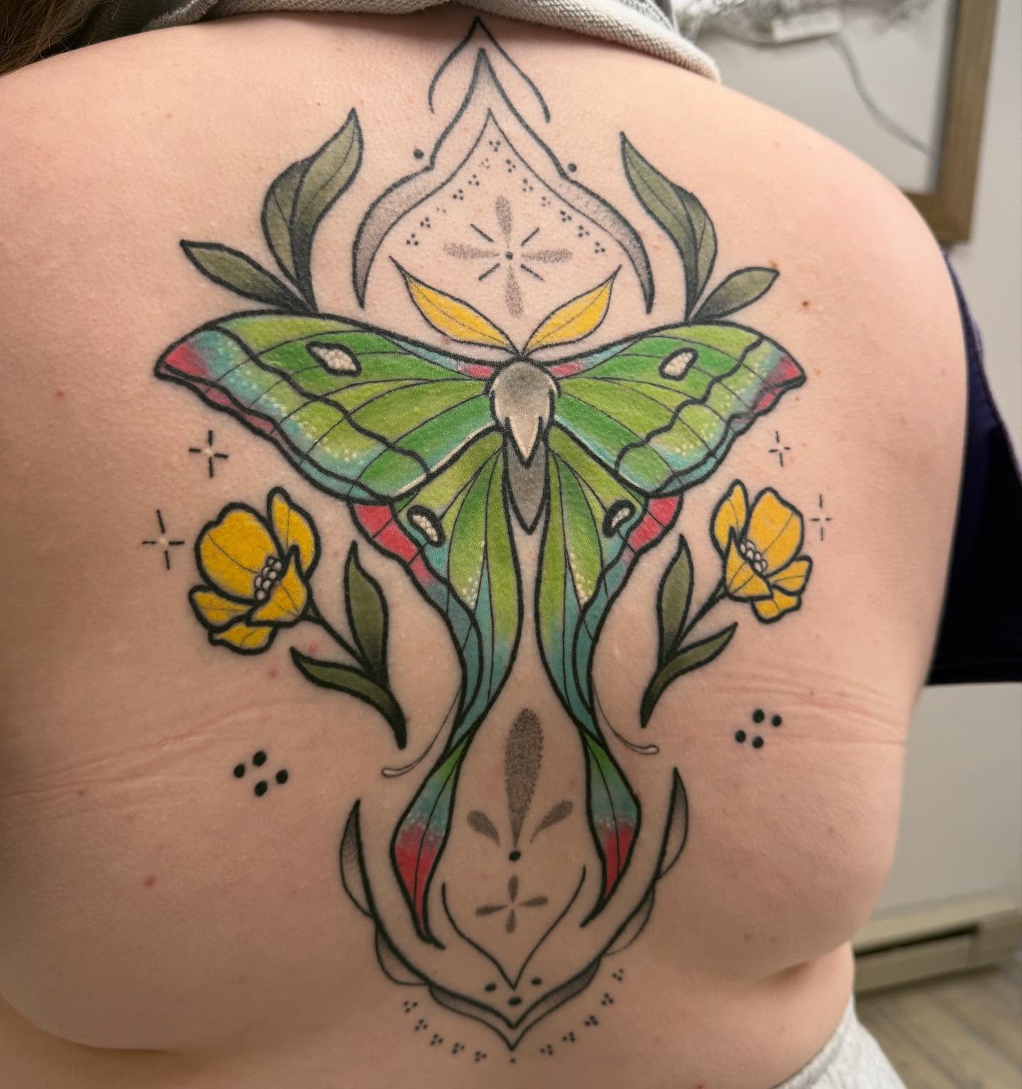 Luna moth and flowers American traditional tattoo on the back by Dameetra Davis