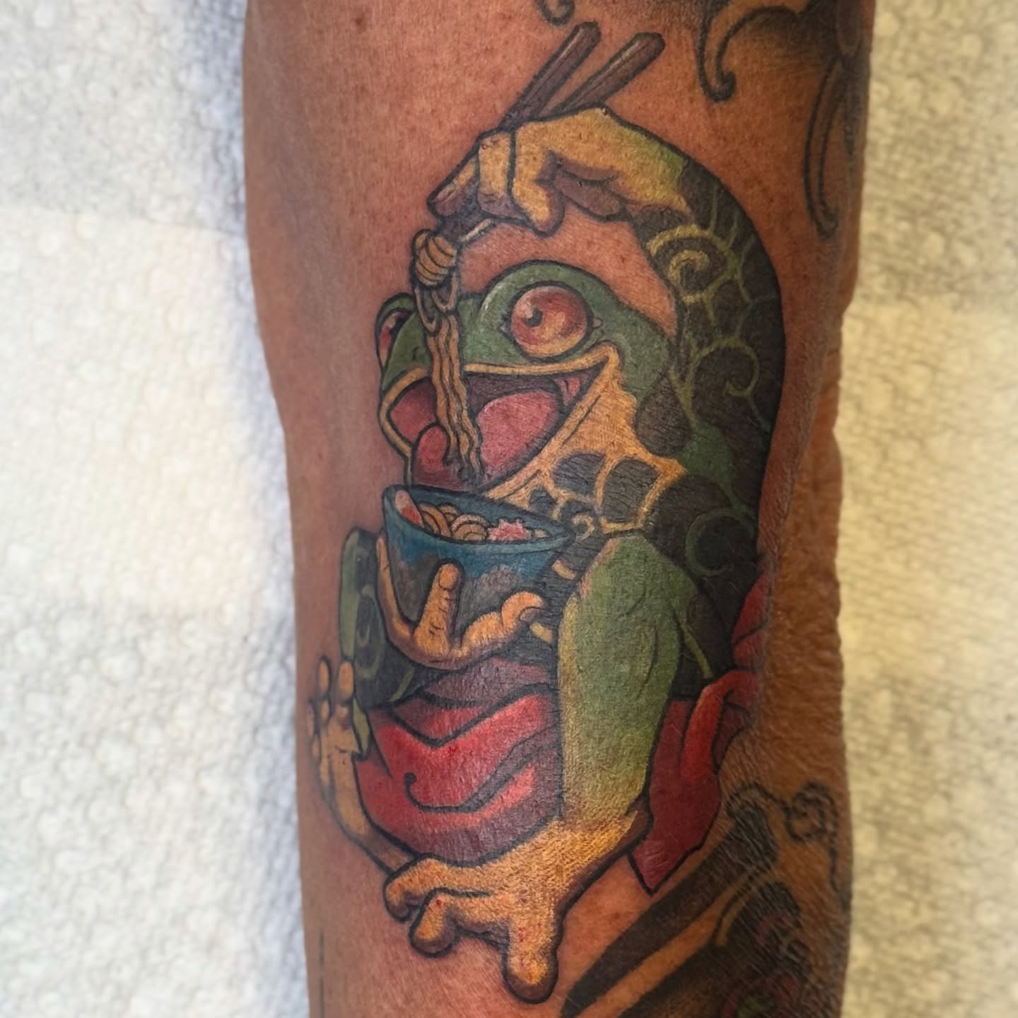 Frog eating noodles new school tattoo on the forearm by Bri