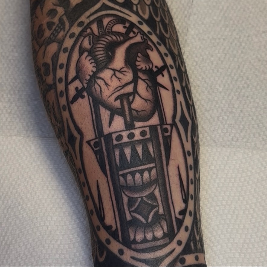 Heart in cage black and grey tattoo on the forearm by Cory Allen