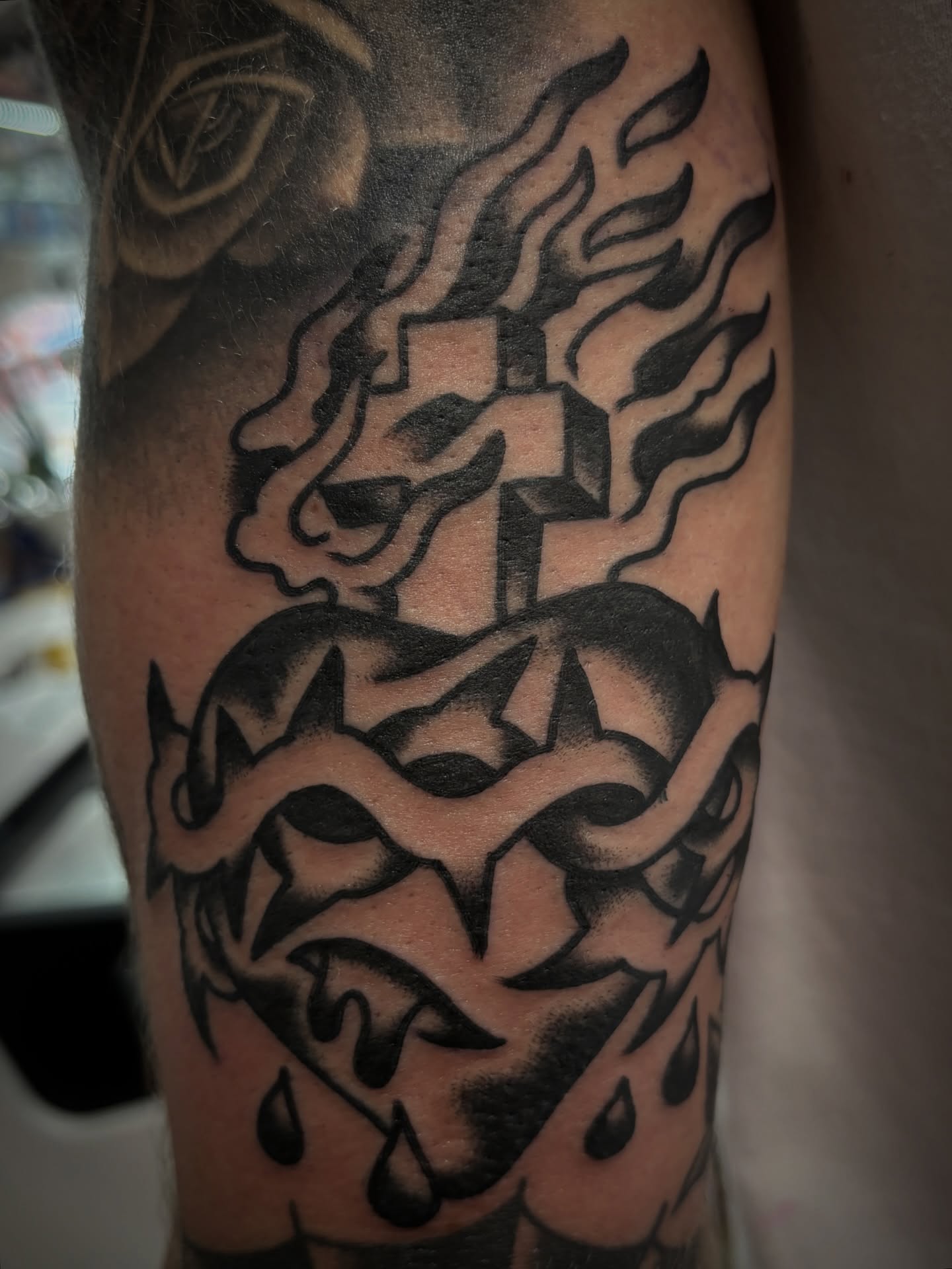 Flaming heart with cross black and grey tattoo on the forearm by Carlos Gonzalez Tattoo, Dallas, Texas